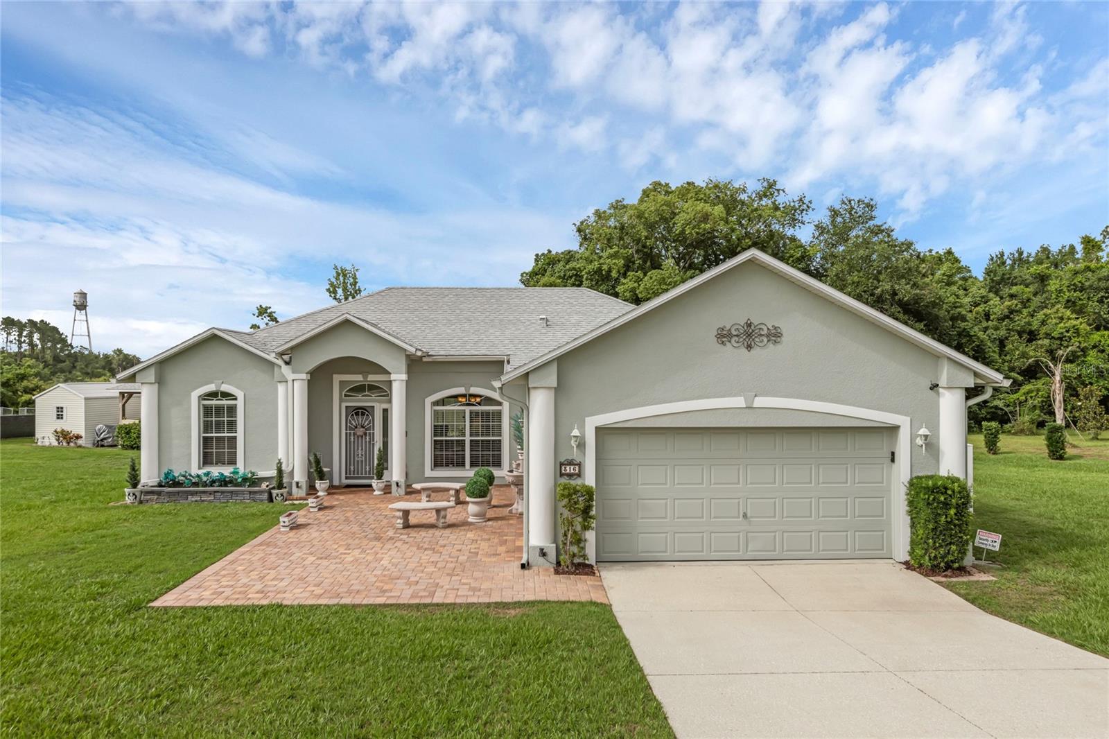 Welcome to this beautifully maintained and custom-built home located in the peaceful and highly desirable town of Howey-in-the-Hills. This well-loved residence sits on three oversized lots totaling 0.84 acres, with no HOA, and offers 1,829 square feet of living space plus an oversized garage. Inside, the home includes 3 bedrooms, 2 full bathrooms, and a versatile bonus room—perfect for use as a home office, nursery, guest room, or den. The spacious living room features vaulted ceilings that continue through the kitchen, dinette, and dining areas. The kitchen and bathrooms are outfitted with quartz countertops and matching backsplash, and new refrigerator (2023). Ideal for entertaining, the property includes a covered pavilion with paver brick flooring, ceiling fan, electricity, outdoor grill and excellent Wi-Fi connectivity, a tiled, screened-in sunroom at the rear of the house, and a front patio with pavers, a decorative fountain, built-in benches. The home also includes a Trane central HVAC system, and a Pelican water filtration system, a new roof installed in November 2023 with a 50-year transferrable warranty, a new water heater 2023, rain gutters surrounding the home, five Ring security cameras, and is wired for Quantum Fiber Internet with cable outlets in every room. The property also includes a 12’ x 12’ hurricane-rated shed and comes with a Toro 50” zero-turn radius mower. Located just five blocks from Little Lake Harris, and only five miles from the Florida Turnpike, this unique and well-equipped home is truly a rare find in Central Florida.