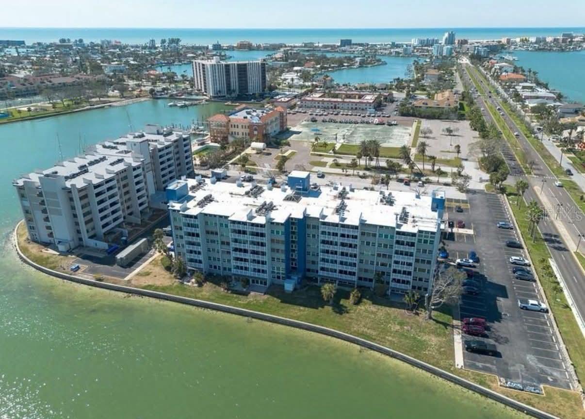 Clean and Updated, Convenient location, Close to the Beaches and an easy drive to DTSP. Pet friendly building with a fresh new face, paint and flooring in common areas too. Walk or bike (bike storage on Main floor) to TI beach, shopping district and restaurants. Full size W/D included for convenience en-suite, primary bath is large enough for two to get ready and not be in the others way. Large ceramic tile flooring & Plenty of closet space and storage throughout. The large balcony off living room provides space to enjoy the beautiful sunsets (high top table and 2 chairs provided). Open-floor plan... Mounted TV in living room conveys and stainless steel appliances in the kitchen, half bath and primary updated as well. Come live the Florida lifestyle! Cable, internet, water and trash included in monthly rent, you just pay electric. Assigned parking, secure building, ample guest parking.