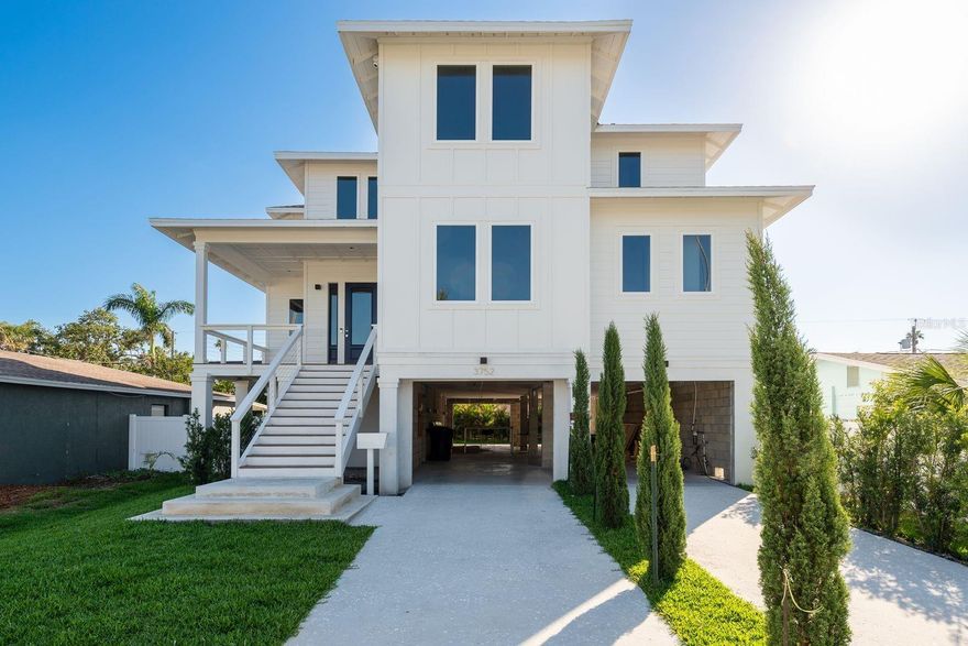 Step into an extraordinary expression of architectural elegance and modern luxury with this exceptional brand-new construction estate, built by Iridium Development and nestled in the highly sought-after enclave of Northeast St. Petersburg. Meticulously crafted with an uncompromising attention to detail, this 5-bedroom, 4.5-bath residence spans 3,275 square feet of refined interiors and boasts a rare 5-car garage—perfect for car enthusiasts or extra storage. The exterior is wrapped in durable Hardie cement siding and fortified with hurricane impact-rated windows and doors for long-term peace of mind.

Inside, soaring 10-foot ceilings, 8” wide-plank oak flooring, and custom millwork create a warm and inviting ambiance throughout. At the heart of the home, a gourmet kitchen awaits—already outfitted with top-of-the-line Viking appliances, beautiful shaker-style cabinetry, and bold contemporary finishes. The kitchen flows seamlessly into expansive open living areas, ideal for gatherings both intimate and grand.

A showstopping, glass-encased 65-bottle wine cellar—climate-controlled, LED-lit, and secured—anchors the home's intricate entertaining experience. Every finish throughout the home has been thoughtfully curated, including Level 5 smooth-finish drywall, spa-inspired European bathrooms, custom interior doors with premium hardware, engineered HVAC, instant hot water, and a full-house water filtration system with isolated plumbing mains.

Designed with the future in mind, the home is prepped for a built-in elevator and smart home expansion. Outdoors, enjoy a private, manicured yard with ample space to design your own outdoor retreat—whether it’s a pool, garden, or entertainment space.

Located in the desirable Shore Acres Overlook neighborhood, you’re just minutes from top-rated schools, waterfront parks, golf courses, and the vibrant downtown St. Pete waterfront with its award-winning restaurants, arts scene, and marinas.

This is more than a home—it’s a rare opportunity to own a move-in ready luxury estate that blends timeless craftsmanship with modern flexibility. One or more photo(s) has been virtually staged.
