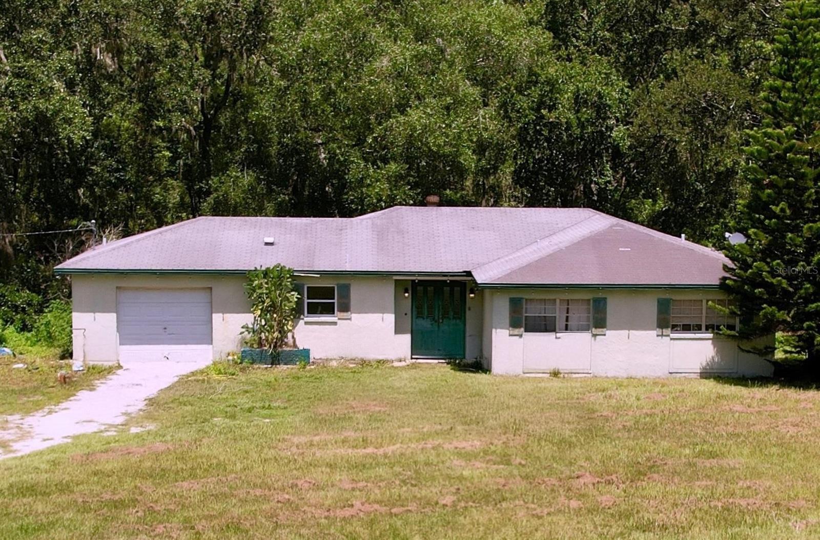 This 2-bedroom, 2-bathroom home with a den is nestled on a spacious 4.77-acre lot, offering the perfect opportunity for anyone looking to bring their vision to life! A great fixer-upper, this property is ideal for those with a passion for renovation or development. The land is level and mostly cleared, with room to grow or subdivide. With its agricultural zoning, the property is perfect for farming, gardening, or keeping livestock. A small stable is already on-site, making it ideal for horse owners. Additionally, there’s potential for subdividing the land into min. 1-acre lots, offering excellent investment opportunities. The property also includes a 1-car garage, providing additional storage and parking
This property is a cash-only sale, and it is being sold as-is due to its fixer-upper status. However, the land’s potential is limitless. Whether you’re looking to renovate the home, develop the land, or enjoy rural living with room for your horses, this property offers something for everyone. The location provides the perfect balance of privacy and tranquility, while still being within reach of Wesley Chapel, making it an ideal spot for anyone seeking peace and quiet.
Don’t miss out on this rare opportunity to own nearly 5 acres of land with development potential in a quiet, agricultural setting. Bring your creativity, horses, and dreams—this property is waiting for you!