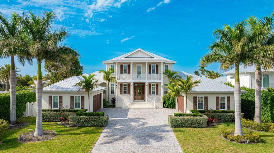 Timeless classic British West Indies inspired home located on a deep water canal with easy access to Bimini Bay and the Intracoastal Waterway. This home offers beauty and privacy inside and out, with mature landscaping, coffered ceilings in the living, dining, and kitchen areas, as well as French doors, plantation shutters and engineered hardwood flooring throughout.  The chef’s kitchen features solid wood custom cabinetry with soft close drawers both here and in the spacious butler’s pantry.  Add stunning granite countertops, a bar area, Wolf and Subzero appliances, a 6 burner gas range, two ovens and a microwave all ready for entertaining.   A private family seating area is adjacent to the kitchen behind French doors creating a great place to relax and enjoy the view or watch TV. A convenient main floor Main Suite offers French doors leading to the lanai, pool, and spa and a large walk in closet The main bath features luxurious Calacatta marble floors and shower walls in the oversize shower, a large soaking tub, and his and hers vanities.  The three welcoming bedrooms on the second floor open out to the covered lanai with views of Bimini Bay.  Each bedroom also has its own ensuite bathroom, each with Calacatta marble floors and individual designs for each shower wall. A large heated salt water pool and spa is surrounded by authentic shell stone which also covers the lanai floor. The Trex dock is equipped with an 8,000 lb. boat lift. Two 2 car garages offer plenty of space for vehicles and storage.  This gracious and serene Moss built home is perfect for the discerning client who is seeking only the finest home.