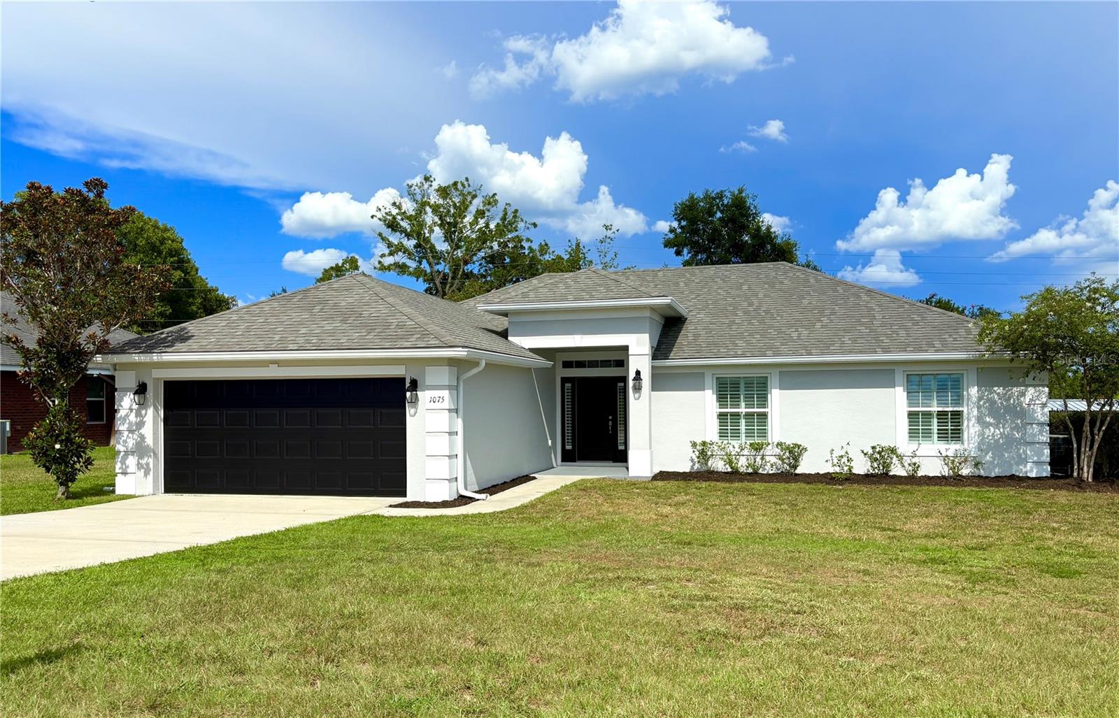 Step inside this spacious, sturdy concrete block home featuring 4-bedroom, 2-bathroom home designed for both comfort and functionality, with an open floor plan, vinyl flooring, and plenty of beautiful natural light. The kitchen offers new stainless steel appliances, abundant cabinets, and a large wraparound counter, opening to a bright living and dining area that flows to a screened patio overlooking the fenced backyard. With fresh paint inside and out, an oversized two-car garage, and a primary suite with double sinks, this home truly has everything you need. Perfectly situated in a highly desirable area close to schools, shopping, and dining, this move-in ready property is waiting for you!