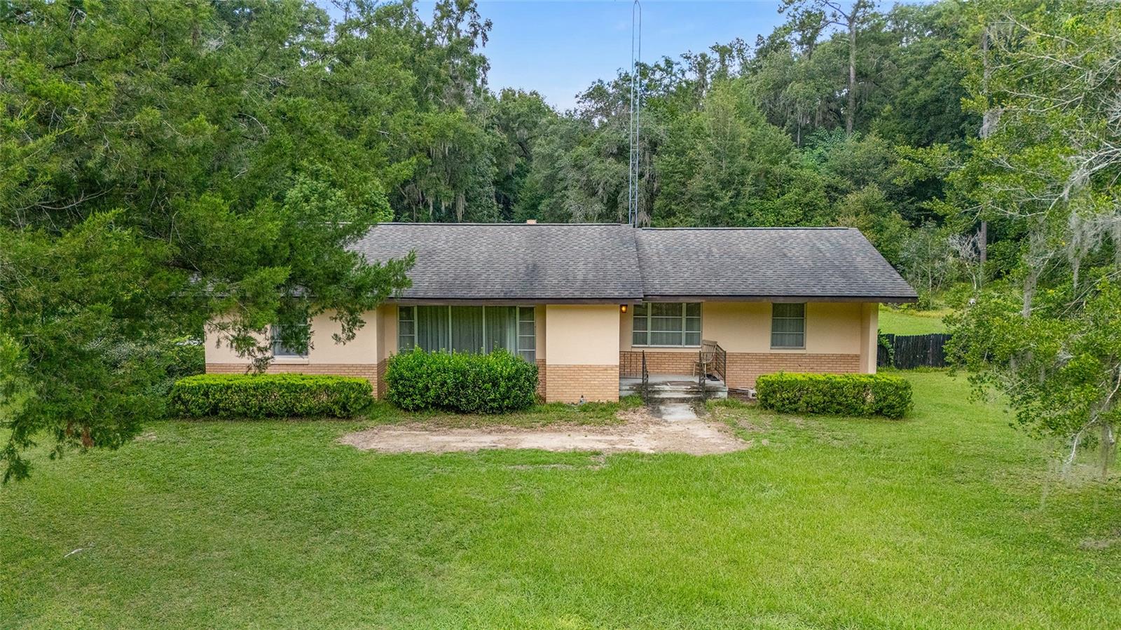 Under contract-accepting backup offers. Great opportunity ~ 20 acre farm property with house, barn, and a gated entrance. No flood zone. This concrete block one owner home has solid bones and is ready for updating. The main house is 1870 ft with 3 bedrooms and 2 bathrooms. Split bedroom plan with a formal living room and dining room. The kitchen has a breakfast bar and is open to the family room with a wood burning fireplace. Large flex space/office. Indoor laundry. The two car detached garage has an additional bedroom and bathroom (apartment or in-law suite with private entrance). 2012 Roof. The property is zoned A-1 so you can have horses, cattle, or chickens! No HOA. There is a fenced paddock in the front of the property and a barn and outbuildings. Conveniently located between Ocala and The Villages, it offers easy access to dining, shopping, medical, and entertainment. It is also close to the Florida Horse Park and the Florida Greenways and Trails.