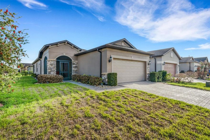 This meticulously maintained Steel Creek model with Sunroom located on a corner lot just a short walk from the Clubhouse in the beautiful and desirable Del Webb Orlando 55+ resort style community has 2 bedrooms and 2 baths. Enter the home through the screened-in front porch and beautiful glass front door into the open floorplan. The kitchen includes a nook, which can be used as an eat-in kitchen or small office space. The kitchen also includes a large island providing ample work space or room for bar stools, solid wood cabinets with pull-outs, granite countertops and stainless steel appliances, including a NATURAL GAS range. Lastly, there is a large pantry boasting shelving which is fully lit. The dining area and great room, enlarged with an enclosed sunroom, are located near the kitchen. Outside is a peaceful covered, screened lanai, complimented with a paver patio, great for relaxing. Concrete landscaping surrounds the house, and new border trees have recently been added to the backyard. The owner’s suite is located in the rear of the home and features an on-suite with large walk-in closet, granite countertops, a linen closet and a large shower. The second bedroom and bath are located near the front of the home providing privacy for guests. The garage features an epoxy floors and overhead storage racks. When the power goes out, the 22K GENERAC GENERATOR kicks on and keeps the household running! And speaking of power, enjoy low energy costs due to the fully-owned SOLAR PANELS. Additional upgrades include hardwood floors throughout, plantation shutters throughout, ceiling fans, rounded corners, and storm toppers offering protection for the windows and doors ($4500 value).  The $282 monthly Del Webb HOA fee includes yard maintenance and exclusive access to resident-owned 30,000+ SF Montecito clubhouse and amenities. $425 semi-annual HOA fee provides 24x7 staffed security gate and master association-owned private road maintenance. Adjacent to recently renovated 18-hole White Heron Golf Club. DEL WEBB ORLANDO is a 55+ community with a tavern, indoor walking track, indoor and outdoor pools and spas and fitness center. Outdoor activities include tennis, bocce, basketball and pickleball. Miles of biking and walking trails within Ridgewood Lakes gated community. Located conveniently to shopping at Posner Park (4 miles), Disney World, Universal Studios, Orlando & Central FL entertainment nearby. Easy access to I-4, medical facilities, airports & Sunrail Station. Advent Health hospital is 3 miles away.