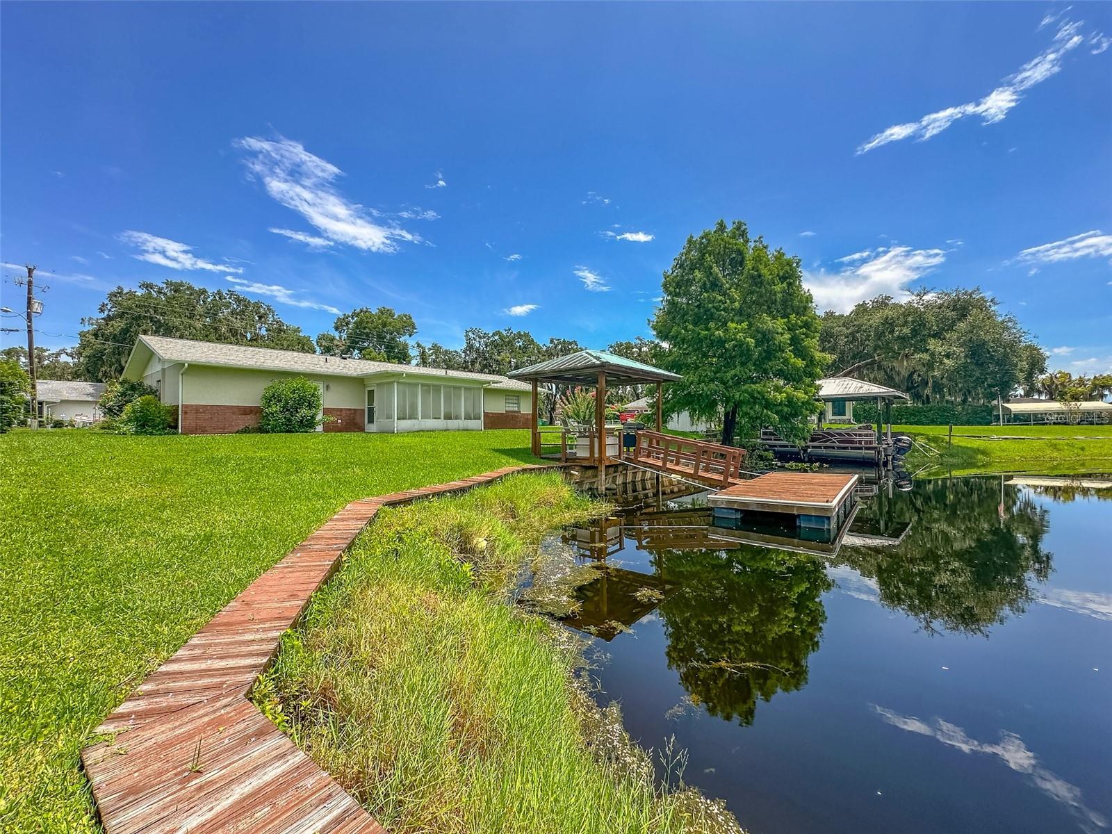 Welcome to your serene LAKEFRONT retreat in Inverness, Florida. This cozy 2-Bedroom, 2-Bathroom home offers peaceful WATERFRONT living, nestled along Little Lake Spivey—part of the expansive Tsala Apopka Chain of Lakes, which includes Lake Lloyd, Lake Henderson, and Little Lake Henderson. Begin your day with stunning SUNRISE VIEWS from your COVERED DECK, complete with a FLOATING DOCK—perfect for quiet moments or entertaining guests. Inside, a bright and airy OPEN-CONCEPT Living and Dining area flows effortlessly into a spacious Lanai overlooking the Lake, ideal for relaxation or hosting gatherings. The well-appointed Kitchen features Soft-Close Cabinetry and Stainless-Steel Appliances, blending efficiency with style. Just off the main living space, the Primary Suite includes a Private En Suite Bathroom, while the Second Bedroom sits conveniently beside the Guest Bathroom. A One-Car Garage with a Laundry area completes the thoughtful layout. Enjoy everyday comfort and laid-back lakeside living in a home ideally located near everything Inverness has to offer—from local Dining and Shopping to world-class Trails and Scenic Parks. No HOA - Roof 2023-Permit #20230346. All information provided in this report is believed true and accurate at data entry but not guaranteed. Buyer / Buyer's Agent to verify all interior room/exterior-deck/dock measurements.