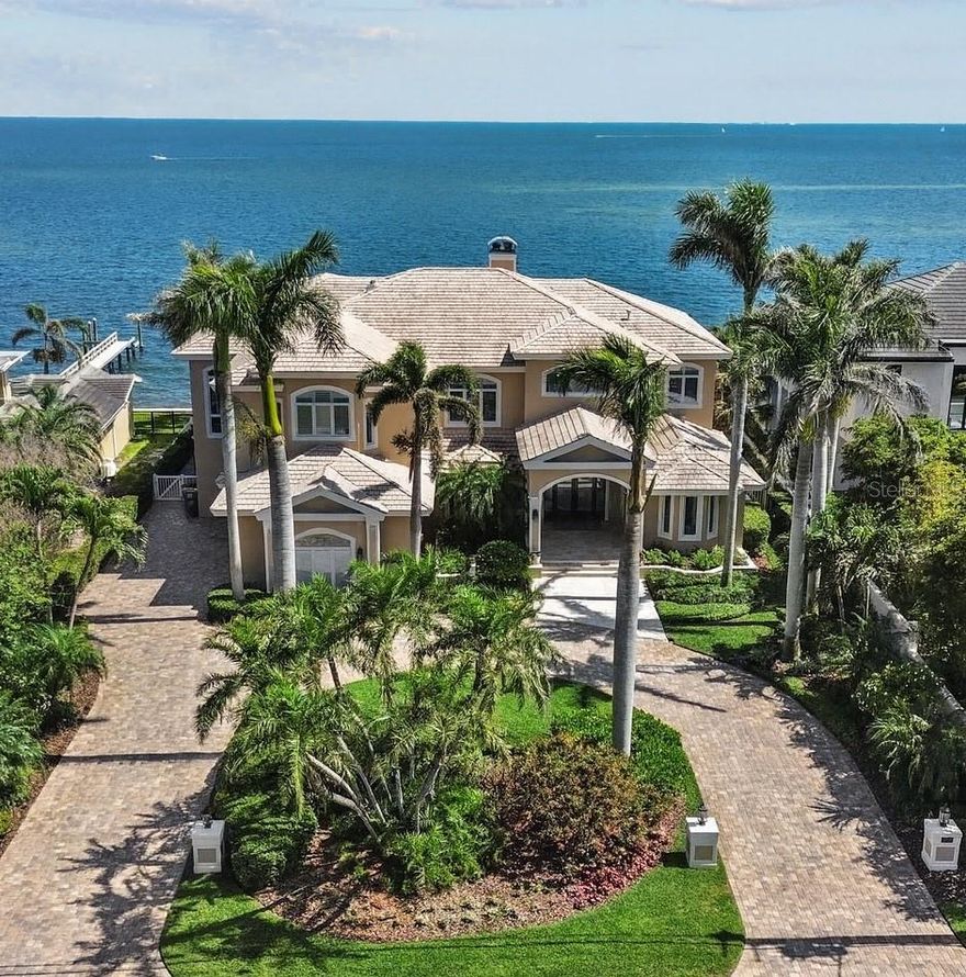 One or more photo(s) has been virtually staged. Set along the coveted Brightwaters Boulevard on Snell Isle, this exceptional waterfront estate offers nearly half an acre of prime property with 104 feet of direct water frontage and sweeping views of Tampa Bay and the iconic downtown St. Petersburg skyline. Encompassing 7,710 square feet of thoughtfully designed living space, this elegant custom-built residence masterfully blends luxury, functionality, and effortless entertaining. The home features four spacious bedrooms—all with en-suite baths—plus three additional half baths, a stately executive office, a private home theater, a large game room, and an oversized three-car garage. Constructed with superior block-to-top construction and a durable concrete tile roof, every inch of this home reflects quality and craftsmanship. Through majestic artisan glass double doors, a grand two-story foyer welcomes you with a dazzling custom hand-blown glass chandelier and sconces that accentuate the sweeping staircase. The formal living and dining rooms offer a dramatic introduction, showcasing floor-to-ceiling French doors that frame breathtaking vistas of the Bay. Step outside to your private waterfront oasis—complete with a sparkling resort-style pool, expansive travertine sundeck, covered lanai, outdoor kitchen and bar, and a private dock—all set against a backdrop of glistening water and skyline views. Inside, the expansive family room is perfect for gathering, featuring a full Sub-Zero wine refrigerator, dry bar, and massive picture windows that invite the outdoors in. The chef’s kitchen is a culinary masterpiece, equipped with a Sub-Zero refrigerator and freezer, Thermador six-burner gas range and hood, Dacor double ovens with warming drawer, Miele dishwasher, dual Sub-Zero drawer fridges, custom hardwood cabinetry, granite countertops, a large center island, and a walk-in butler’s pantry with built-in desk, ice maker, and additional storage. A charming breakfast nook offers more mesmerizing Bay views. The first-floor guest suite provides a private retreat, opening directly to the lanai and pool—ideal as a main-level primary suite or luxurious accommodations for visitors. A richly appointed home office with a cherry wood coffered ceiling completes the south wing. Upstairs, enjoy endless hours of recreation in the game room and private theater. Two guest suites offer walk-in closets, en-suite baths, and access to a shared Bayfront balcony. The opulent owner’s suite is a sanctuary unto itself, featuring a generous waterfront seating area, two custom walk-in closets, and a private balcony with unmatched views of downtown St. Pete and Tampa Bay. The spa-inspired primary bath includes dual vanities with marble countertops, a jetted soaking tub overlooking the Bay, a glass-enclosed shower, and a private water closet. Additional features include soaring ceilings, gleaming travertine and hardwood flooring, a well-appointed laundry room, service stairwell, abundant storage, potential for a garage lift, multiple outdoor lounge and dining areas, and pristine tropical landscaping. All of this is just minutes from the Vinoy Golf Club, 4th Street shopping and dining, and the vibrant energy of downtown St. Petersburg’s waterfront parks, art museums, fine restaurants, boutiques, nightlife, and sporting events. Quick access to I-275 places Tampa International Airport and points south within easy reach. This more than a home—it's a lifestyle.