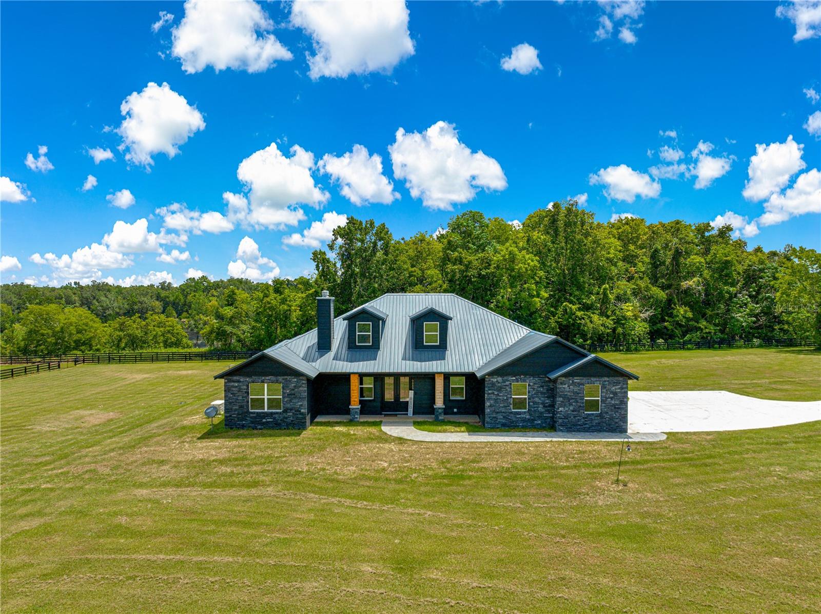Wow! Check out this 2024, custom built 2952 sq ft, 4/3/2, pool home on 3.42 acres. Completely surrounded by a no-climb, 4 board fence, and electric gate, this home is ready for whatever your imagination desires. The outdoor features include a metal roof, whole home generator, hot tub and of course we can't forget the heated, saltwater pool. As you walk through the front door you are invited in by the open floor plan, but your eyes will immediately focus on the completely custom kitchen. It features a double oven, built in microwave, cooktop with pot filler, farmhouse style sink, and a massive eat-at island. The granite counter tops and solid wood cabinets are elegant and functional, not to mention the walk-in pantry. Downstairs there are three bedrooms and 2 bathrooms on one side of the home, and the Primary bedroom and bathroom are on the other side. The primary suite was fully designed with luxury in mind. It has an oversized walk-in shower and a closet that is big enough to be another bedroom. Upstairs is a massive bonus room, that has it's own A/C unit to keep it cool, perfect for a game room, or office, etc. Out back on the pool deck is yet another bonus room, that has it's own entrance and is perfect for outdoor entertaining, a card room, man cave, etc. Being built in 2024, this home is under the contractor warranty until November, 2025. Come take a look, I promise you won't be disappointed.