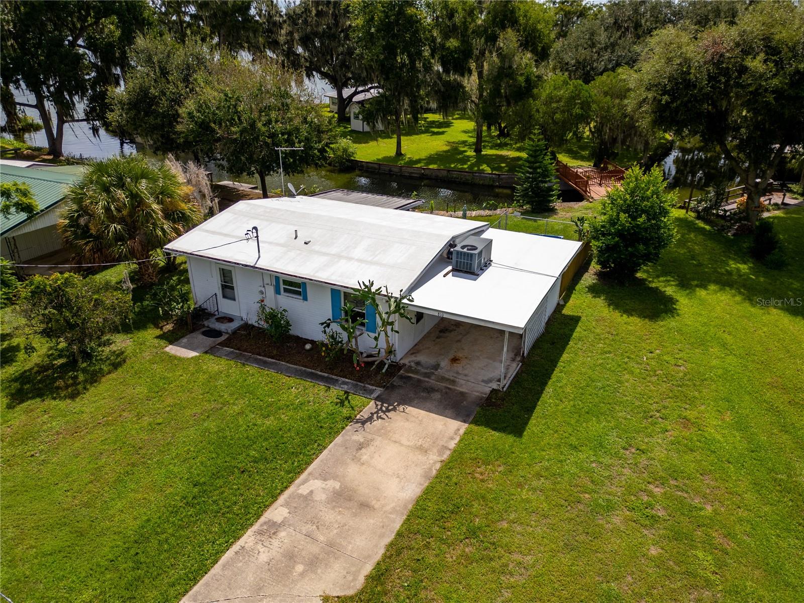 Under contract-accepting backup offers. Discover an exceptional opportunity to own a charming two-bedroom, one-bathroom home nestled along a serene canal with stunning lake views in the highly sought-after Tracey’s Point neighborhood of Lake Panasoffkee, Florida. Perfect for water enthusiasts, this property offers direct lake access, inviting you to bring your boat and immerse yourself in a variety of exciting water activities. Ideally situated, the home is conveniently located near the turnpike and I-75, providing seamless access to airports, world-class amusement parks, and beautiful beaches. Positioned between the tranquil Lake Panasoffkee and the scenic Withlacoochee River, this residence combines the allure of waterfront living with unmatched convenience, making it the perfect place to call home. The home features a single car-carport which houses the laundry, a relaxing screened-in lanai for entertaining and some updates. Updates including 2014 Water heater and 2014 200 Amp Electrical upgrade. Schedule a private tour today!