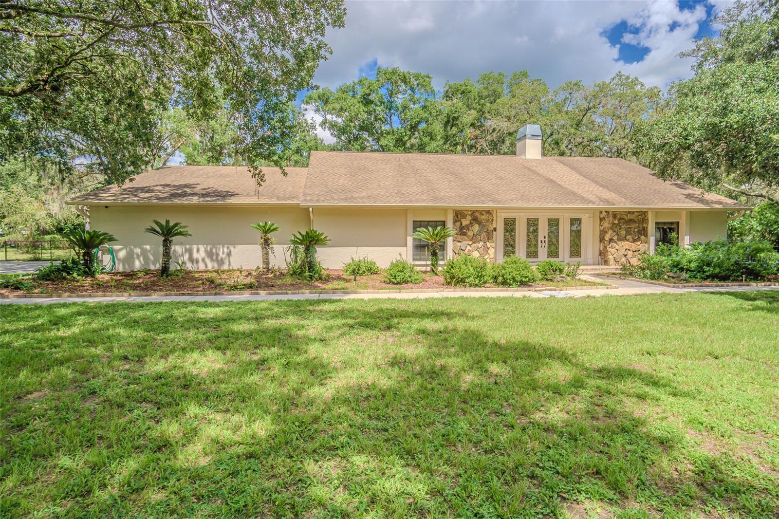 Your Private Country Retreat in the Heart of Lutz Spacious • Serene • One-of-a-Kind. Estates of this Caliber do not come along often. Great neighborhood. Welcome to a rare sanctuary where peaceful country living meets everyday convenience — nestled on 1.52 acres in a quiet, non-deed restricted neighborhood in Lutz. This custom-designed estate offers a lifestyle of relaxed elegance, with space to breathe, entertain, and connect with nature. From the moment you arrive, you are welcomed by the majestic Grand Oaks, vibrant landscaping, and the unmistakable calm of a home that has been loved. Wildlife sightings—deer at dawn and songbirds in the trees—are your daily backdrop. Inside, this 4-bedroom, 2 full and 2 half-bath home offers over 3,100 square feet of beautifully finished living space (4,100+ under roof), thoughtfully crafted for both entertaining and everyday living. Step through double lead-glass doors into a warm, open layout accented by natural wood floors and stone details. At its heart is a true chef’s kitchen featuring custom cabinetry, over 30+' of granite countertops, stainless steel appliances, double ovens, a warming drawer, and a cooktop with vent hood — all seamlessly open to the expansive great room, 17x28. The Kitchen, 20x14, and Dining room, 13x15, are open to the Living room which has soaring cedar cathedral ceilings and a large wood-burning fireplace creating a stunning yet cozy gathering space. Host formal dinners in the elegant dining room with crown molding and chair rail accents. Unwind in the oversized primary suite, 17x16, a true retreat with patio access and a spa-style ensuite: dual comfort-height granite vanities, a walk-in mosaic tile shower includes a rain shower head, and private water closet with cabinets for an elegant linen closet. Near the primary suite is the first guest bedroom, 12x16, which can be used as an office. A split-bedroom layout ensures privacy, including two generous secondary bedrooms that have a unique jack-n-jill bathroom with each bedroom having their own half bath and sharing the shower in between. The secondary guest bedrooms, 19x14, & 17 x 12, are located on the separate side of the home and each one has two spacious closets and between the closet is a large linen closet for ample storage. One of the guest bedrooms has direct sliding-door access to the covered and screened patio. Directly off the Kitchen is the Guest Half Bath and the Delightfully massive laundry/utility room, 08x20, with built-in cabinetry that seem to go on and on. More upper cabinets over the granite counter including a full sink with a hookup for a secondary Refrigerator. Stepping outside to an entertainer’s dream: a large, screened lanai, 32x11, with a pass-through kitchen bar, perfect for weekend barbecues or quiet evenings under the stars. Additional Highlights: Real wood floors throughout. Large Side-entry 2-car garage, 20x27, Detached gazebo for morning coffee or sunset views, 2-stall horse stable with tack room, water & electric, Double-pane windows & doors for energy efficiency, Pull-down attic storage, Two-zone A/C system, Attic space with ample height and space for additional storage area. Bring your family, your pets — even your horses. With no HOA restrictions, you will enjoy true freedom in one of Lutz’s most desirable hidden-gem locations. This is not just a home — it is a lifestyle. Come experience the peaceful charm and unmatched comfort for yourself. You may never want to leave. Video Attached.