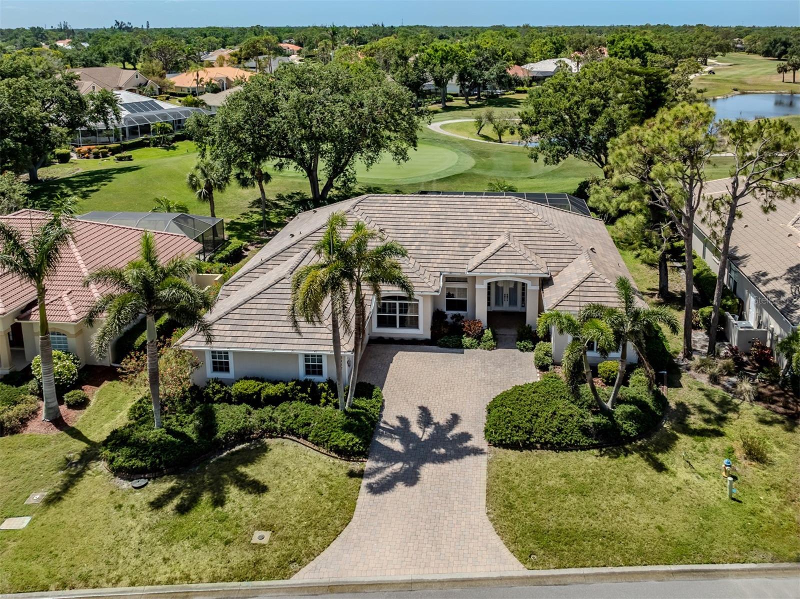 Experience luxury living in this beautiful custom home, positioned with serene views down the 11th fairway and a peaceful lake. Boasting spacious bedrooms, a private study, versatile bonus room and a split floor plan ensuring privacy, this residence offers comfort and flexibility. Notable features include volume and tray ceilings, crown molding, and a new roof in 2024. The well-designed kitchen is a chef's dream, featuring maple cabinetry, granite countertops, walk-in pantry, built-in desk and breakfast bar. It opens seamlessly to the breakfast nook with its aquarium windows and a welcoming family room, highlighted by sliding glass doors that lead out to the lanai. For formal occasions, enjoy the elegant dining room and living room with slider access to the lanai. Entertain effortlessly outdoors with a sparkling pool and spa, complemented by a fully equipped outdoor kitchen. The primary suite is set apart behind French doors and offers direct access to the lanai. Its luxurious bath includes a Roman shower, dual vanities, a garden tub and French doors opening to an attached bonus room. The driveway and lanai deck are beautifully finished with pavers for added curb appeal. In the gated community of Calusa Lakes, this home offers access to tennis courts, social activities, and is just minutes from the beach. Golf membership is optional, adding flexibility to your lifestyle.