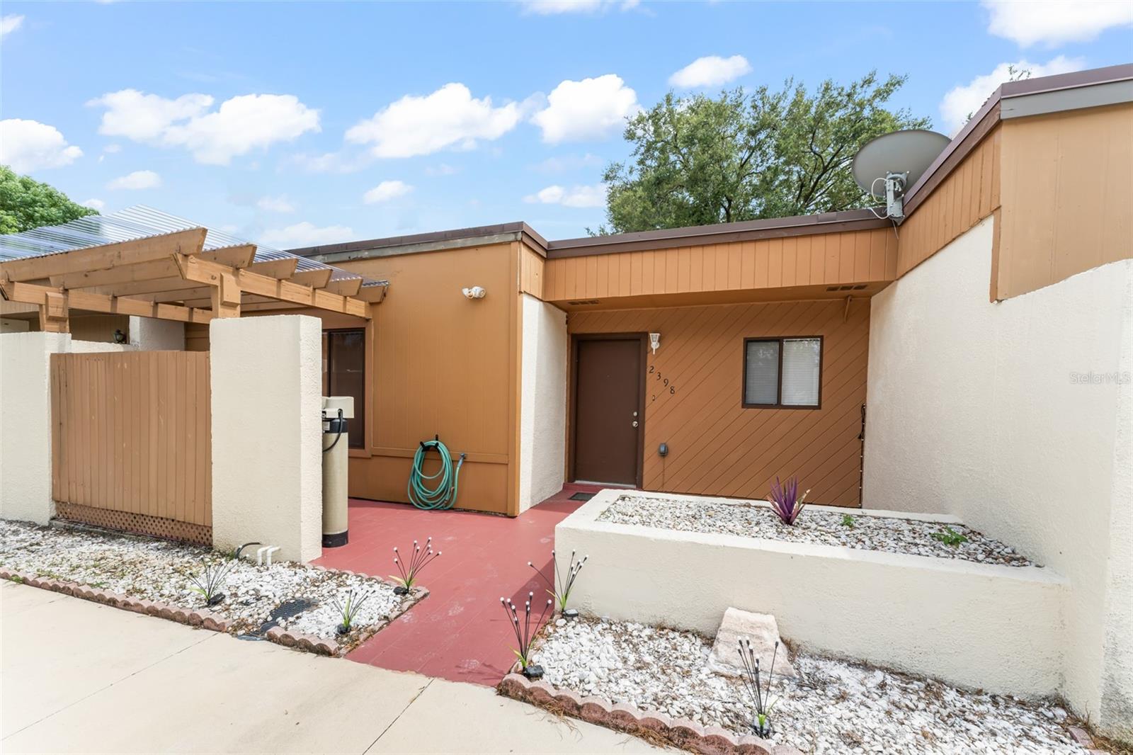 **This property qualifies for a closing cost credit up to $3,900 through the Seller’s preferred lender.** Charming Winter Park Townhome with Vaulted Ceilings and Sun-Filled Spaces. Welcome to 2398 Dominica Way, a beautifully maintained 2-bedroom, 2-bathroom townhome nestled in the heart of Winter Park. From the moment you arrive, you'll be drawn in by the inviting front patio, complete with a pergola and clear roofing—perfect for soaking up the sunshine while staying protected from Florida’s afternoon showers. Step inside and you’re greeted by a warm and functional layout. The kitchen, located just off the entry, boasts rich, warm cabinetry, sleek black and stainless steel appliances, and a serving window that opens into the spacious dining and living room combo, doubling as a breakfast bar for casual meals or entertaining guests. Continue into the main living area, where soaring vaulted ceilings and a wall of glass sliders flood the space with natural light and provide a beautiful view into the Florida room. Off to the left, a private hallway leads to the home’s bedrooms. The guest bedroom overlooks the front patio and features a ceiling fan and easy access to the second full bathroom, which includes a tub/shower combo. Across the hall, the primary suite offers a peaceful retreat with a walk-in closet, an ensuite bathroom with a walk-in shower, and private access to the rear porch through sliding glass doors. The spacious Florida room at the back of the home offers flexible indoor-outdoor living, with direct access to a shared grassy area—perfect for pets, gardening, or simply enjoying the fresh air. Whether you're a first-time homebuyer, downsizing, or looking for a low-maintenance lifestyle in a prime location, this gem in Winter Park is ready to welcome you home.