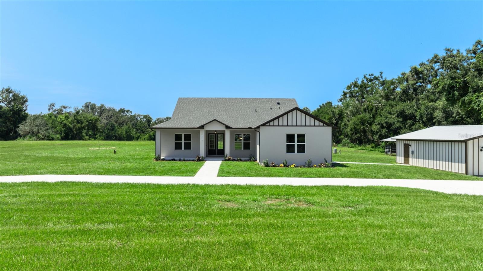 One or more photo(s) has been virtually staged. Welcome to this beautifully crafted modern farmhouse offering 2,522 sq ft of living space, nestled on 7.69 acres in a quiet, secluded location at the end of the road in San Antonio, FL. This property is an oasis of peace and privacy while being just minutes from I-75 and SR 52 for easy commuting. Key features include a spacious, open floor plan, quartz countertops throughout, a large flex room that can be used as an office, playroom, or gym. This property is perfect for animals including horses, livestock, and pets. Ideal for cultivating your dream garden or homestead. The large enclosed pole barn is perfect for additional storage, vehicles, workshop, or equipment, and there is a second open pole barn with stalls. No HOA so enjoy the freedom to personalize. All of this including quick access to major highways yet still tucked away in nature. With the peaceful charm of country living and plenty of room for family, animals, and hobbies, this is the ideal property for anyone looking for space, privacy, and convenience. Schedule a tour today and experience this amazing property!