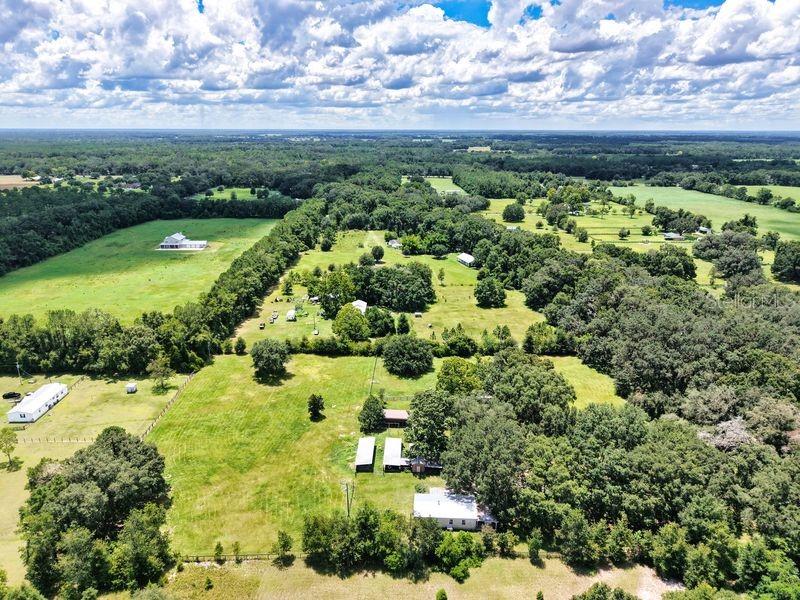 Country living at it's best. When you pull in to the property, you are greeted with a grandiose tree lined drive. What an absolutely amazing horse owners sanctuary, with the barns and stalls to shelter your furry friends. Brand new Metal Roof! Wow! With the elevated bar in the kitchen, you have plenty of room for guests while you prepare a lovely meal on the flat top cook surface. The living room bodes a cozy gas fireplace for those cool days that we actually do get here in FL. The trees on this property are just idyllic.