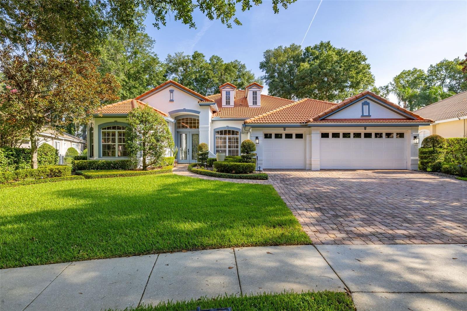 Welcome to 1044 Bloomsbury Run, a beautifully maintained Mediterranean-style residence nestled on a quiet bend in one of Central Florida's most desirable communities. This stunning home boasts impeccable curb appeal with a tile roof, manicured landscaping, and a spacious 3-car garage. A brick paver driveway and elegant arched entryway invite you into a space that blends timeless charm with modern comfort. Surrounded by mature trees and lush greenery, this home offers the perfect mix of privacy and neighborhood living. offering 4 bedrooms, 4 baths, a dedicated executive office, and a spacious bonus/media room. No detail was overlooked, enjoy custom designer finishes, hardwood flooring, and built-ins throughout. The gourmet kitchen features quartz countertops, custom-painted cabinetry, stainless steel appliances, farmhouse sink, and wine cooler. All bathrooms have been tastefully done with marble counters and modern fixtures. The home includes upgraded lighting, roller shades, and plantation shutters. The expansive lanai showcases an outdoor kitchen with a Coyote grill, pavers, and seating area just outside the screen enclosure. Relax by the pool or unwind in the upgraded bonus room with billiards table, media space, granite bar, and Theatre seating. Conveniently located near top ranked restaurants, top tier golf courses, and major highways for easy commutes.