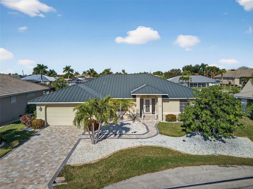 PRIME WATERFRONT LOCATION IN PUNTA GORDA ISLES! Great sailboat or powerboat access in mere minutes to Charlotte Harbor leading to the Gulf! Quiet cul-de-sac street with 95 feet of seawall, 60’ dock with water and electric, plus 27,000 lb. boat lift, this property is a boater's paradise. Enjoy wide deep canal views and gorgeous sunsets in this tranquil setting. Boasting 4 bedrooms, 2 baths, and 2-car garage this waterfront home offers a spacious 2,100 square feet of living space. Upon entering, you'll be greeted by high ceilings, formal living room and diagonal tile flooring leading to family room and with skylights and access to lanai. Light and bright kitchen features wall of windows to lanai, ample cabinetry and breakfast bar for casual dining. The primary suite offers slider to lanai and pool and ensuite offering dual vanities, soaking tub, and a walk-in shower. The split bedroom plan ensures privacy. Step outside to discover a  paver patio with a pergola perfect for outdoor entertaining. Additional special features include new metal roof and a/c in 2024, inside laundry room and tropical landscaping. Nestled on a quiet cul-de-sac street with great neighbors, this residence is just minutes from the Yacht Club, Fishermen's Village, and downtown historic Punta Gorda, offering easy access to arts, community events, entertainment, and world-class fishing. The proximity to the SWFL gulf beaches ensures that relaxation and recreation are always within reach. Do not miss this opportunity to own a waterfront home in a popular golf and boating community. Schedule your private showing today!