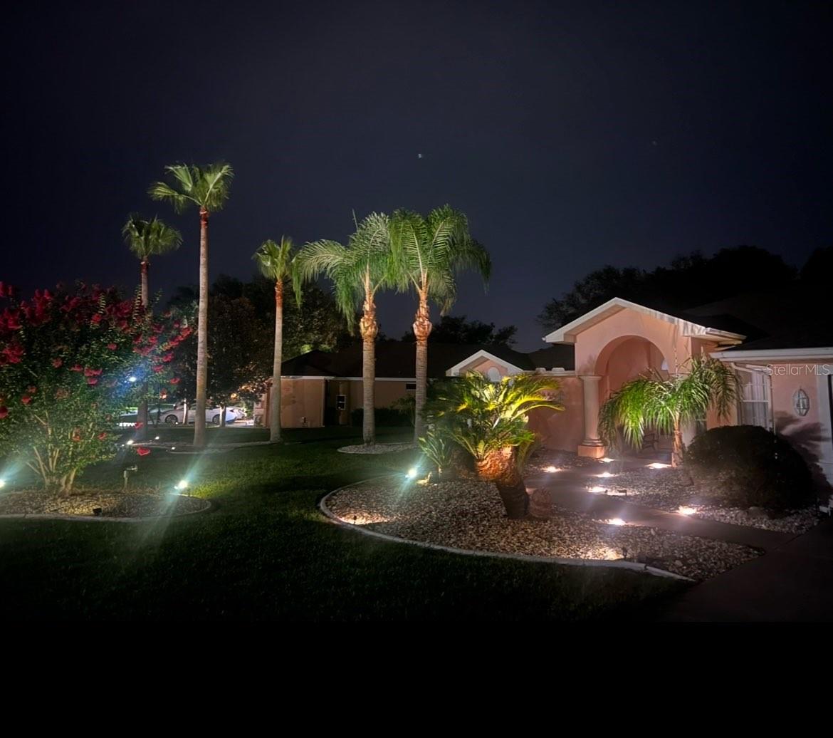 Stunning open concept pool home with 3 bedrooms and 2 1/2 bathrooms in the lovely Pristine Place gated community on a spacious ½ acre lot with private wooded back yard. Enjoy the large sparkling pool area, rain or shine, with a covered lanai/barbecue area which can be expanded into the living/great room by opening the 12 foot wide sliding patio doors. Set the mood by listening to your favorite tunes on the built-in music center that has both inside and outside ceiling speakers. Pool/lanai features an outside shower and an air conditioned ½ bath with a convenient changing bench. Notice the great curb appeal at night with stunning accent lights on the palm trees. The tall covered grand entrance porch has two majestic pillars that frame the pretty oval glass decorated double entrance doors. Enter the home and be awed by the spacious cathedral ceilings, the beautiful wood floors that run from room to room, and the pool view on the other side of the open concept great room. Upgraded kitchen has bright diffused lighting as well as recessed lights, lovely granite countertops and backsplashes, plus a breakfast bar open to the living/dining/great room. Custom cabinetry includes a built-in desk with overhead lights, cabinets and a bookshelf with dividers. Enjoy your morning coffee in the kitchen dining nook overlooking the backyard pool or step out the door and enjoy your breakfast poolside. Spacious primary bedroom has sliding patio doors to enjoy the pool view, a comfortable ceiling fan, mirrored doors on the large walk-in closet and double wide closet in the hall leading to the lovely large ensuite bathroom which has 14 feet of granite countertops, three large mirrors, two sinks, and a make up vanity. Relax and enjoy the ensuite bathroom jetted garden bathtub or use the large separate walk-in shower. Special features include lovely bright glass block window, marble look tile floor, space saving pocket entrance door, a good size linen closet plus lots of storage in the lower cabinets and drawers. Oversized two car garage has a workbench with pegboard, storage cabinets, two cedar lined closets, pull down stairs to access attic storage and a side entrance door. Upgrades include a new range and dishwasher, new architectural shingle roof (2025) as well as a recently re-screened pool enclosure and a new garage door in 2017. Conveniently located just off the Suncoast Parkway, Pristine Place provides easy access to the vibrant Tampa area, with its shopping, cultural, and recreational attractions. Don’t miss your chance to live in this lovely sought-after community which has a tennis court, playground, community pool, library, exercise and meeting rooms. This well-maintained home blends modern updates with timeless style, offering the perfect retreat for relaxation or entertaining and has an assumable 2.5% VA loan to boot! Don’t miss your chance to live in this sought-after community. Schedule your private showing today!