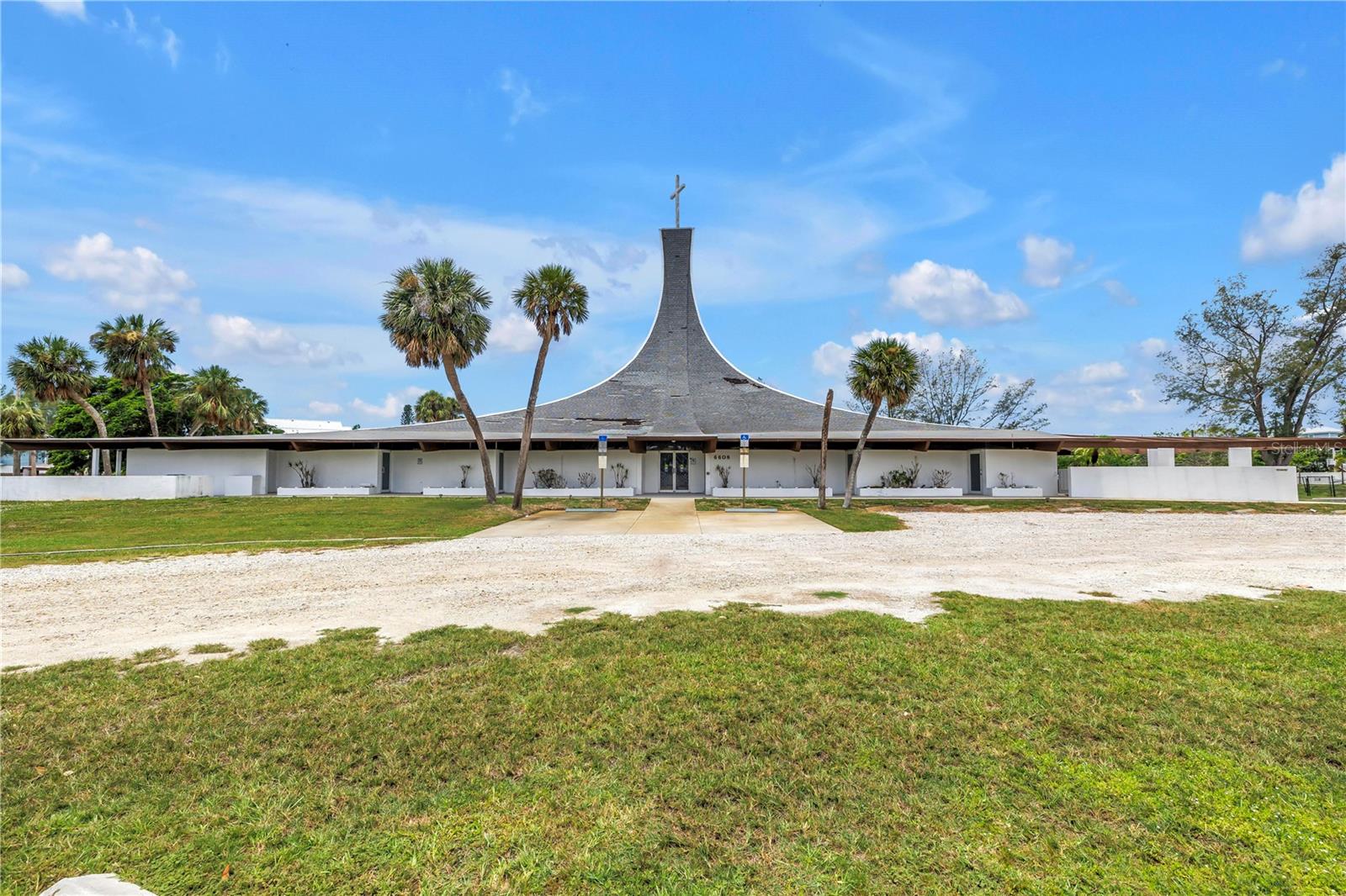 This unique property is for sale and is located on Holmes Beach, situated between the intercoastal waterway and the beach. The interior boasts cathedral ceilings, intricate stained glass, multiple bathrooms, and spacious rooms. The property sits on a triple lot; however, the interior has been affected by Hurricane Helene.