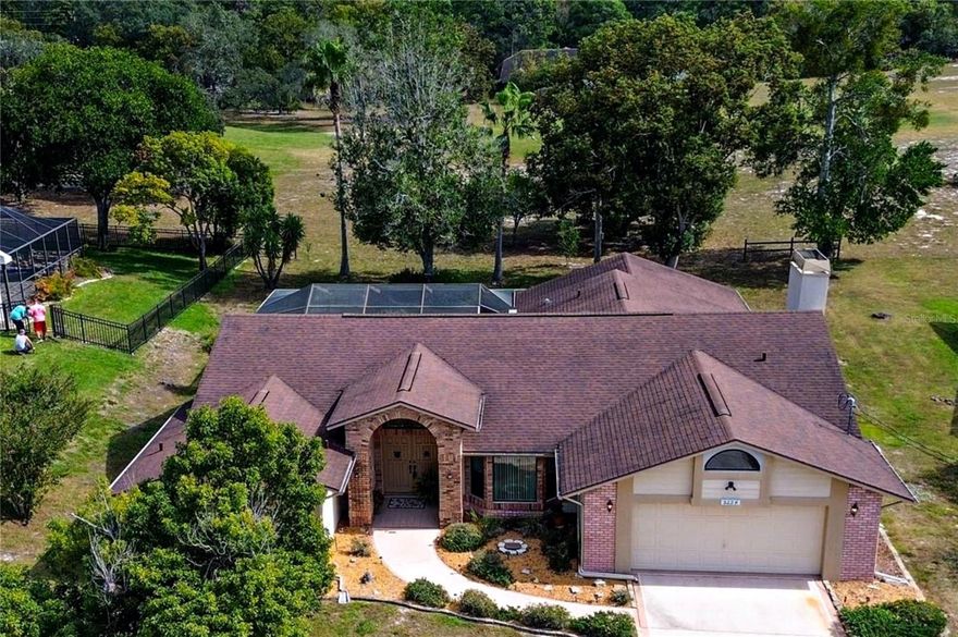 GOLF COURSE FRONTAGE on QUIET STREET! POOL HOME NESTLED ON A 1/3 ACRE (100X150) PRIME GOLF COURSE LOT! NEW HVAC SYSTEM 2022. NEW WINDOWS 2018. NEW FLOORING 2022 (main living areas). Newer roof 2014. This Oak Hills Golf Course home combines the best of modern living with a tranquil and picturesque setting. Whether you're an avid golfer, a nature enthusiast, or someone looking for a serene escape from the hustle and bustle of city life, this house is for you! Enjoy PANORAMIC VIEWS OF THE 12TH FAIRWAY right from your backyard! A highlight of this property is the inviting SWIMMING POOL, perfect for cooling off on hot summer days and promising endless hours of fun! The SPACIOUS COVERED SCREENED LANAI with outside kitchen is perfect for lounging and entertaining friends and family! Step inside to discover spacious rooms with an abundance of natural light, thanks to the many sliding glass doors that line the patio. A triple pocket slider connects the inside to pool area with ease, allowing you to enjoy those beautiful Florida "winter" days. This layout design seamlessly connects the living spaces, making it ideal for both everyday living and entertaining. The gracious kitchen features NEW APPLIANCES, ample cabinet space, and a convenient breakfast bar, making meal preparation a breeze, plus a pass-through window to pool area! The large open Family room features VAULTED CEILING and WOODBURNING FIREPLACE with brick hearth and wood mantel! The generous primary suite is a retreat within itself, offering a spacious sanctuary with GLASS DOORS TO SWIMMING POOL for a midnight dip! You’ll enjoy plenty of closet space and spacious en-suite with dual sinks, separate tub & walk-in shower ensuring your comfort and relaxation, plus private water closet! The remaining two bedrooms are located on the opposite side of the home, provide flexibility for guests or a home office. Both are 13x11 and feature walk in closets! The second bathroom is a CONVENIENT POOL BATH! Large inside utility room and oversize garage are a bonus. Located in a very quiet neighborhood this property has NO HOA or CDD. You'll enjoy the best of both worlds here - the tranquility of nature and the convenience of nearby amenities. Don't miss this incredible opportunity to enjoy a piece of Florida living at its best! Schedule your showing today!