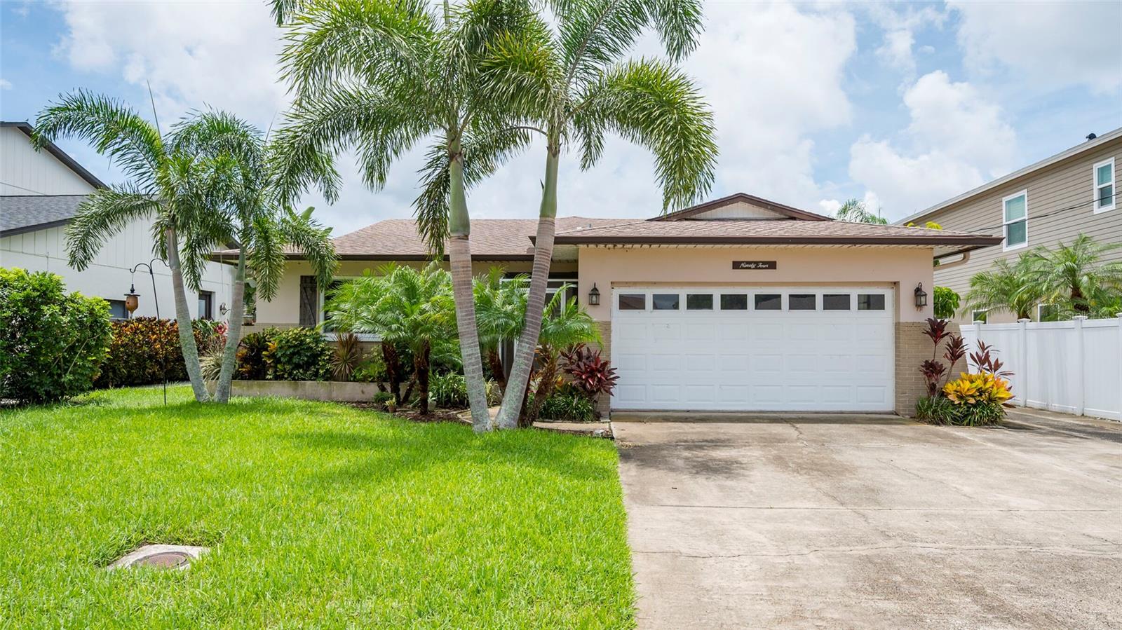WATERFRONT FLORIDA LIVING — NEW ROOF! Situated on a tranquil canal just off Lake Tarpon, this charming 3-bedroom, 2-bath home offers the perfect blend of comfort and lifestyle. A spacious open floor plan includes split bedrooms for added privacy, plus a versatile bonus room that can serve as an office, den, or optional 4th bedroom. The designer kitchen features stainless steel appliances, granite countertops, and custom cabinetry, while the updated bathrooms add a modern touch throughout. Enjoy scenic views from the screened lanai and paver patio that wraps around the waterfront space—ideal for entertaining or relaxing by the water. The home also includes plantation shutters and a covered boathouse for lakeside convenience. The fenced yard and gated sides provide extra privacy. Conveniently located in a desirable Palm Harbor neighborhood with access to top-rated schools, parks, and nearby shopping.