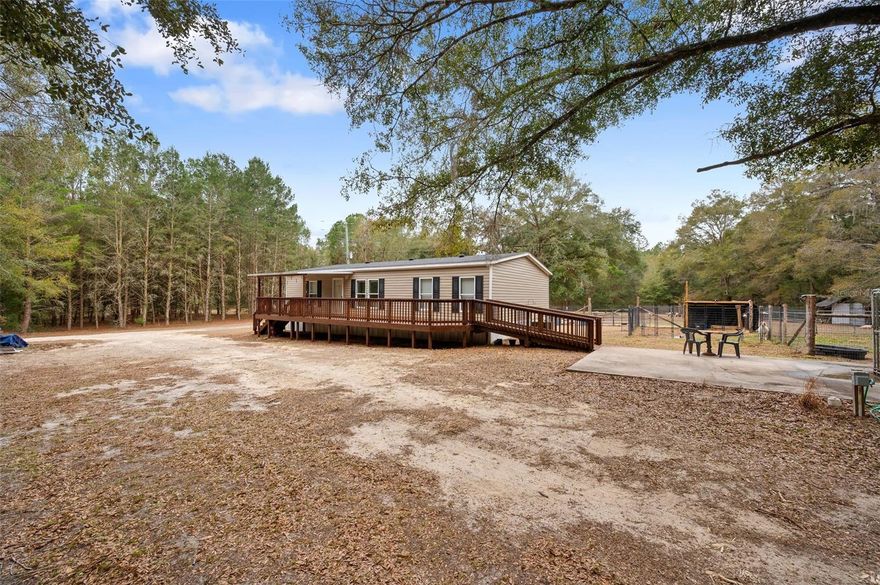 Experience the perfect balance of luxury and practicality in this meticulously maintained double-wide mobile home. Enjoy ultimate privacy with the primary suite situated on the opposite side of the home from the guest bedrooms. It’s the ideal setup for families, roommates, or a dedicated home office. Step into an expansive kitchen featuring a central island, perfect for meal prep or casual morning coffee. Ample cabinetry and modern appliances make this a chef’s delight.  & No more paying for off-site storage. This property includes a dedicated RV hookup, making it easy to keep your rig charged, loaded, and ready for your next excursion. The crowning jewel of the exterior is a massive, custom-built deck. Whether you’re hosting a summer BBQ or watching the deer and turkey pass by, this space effectively doubles your living area. Whether you are looking to become a mini farmer, need a place to rest between road trips, or simply want a private parcel to call home, this is it. Property is within 20 minutes to UF, UF Vet school, VA Hospital, Celebration Pointe, and Butler Plaza. Quick commute to Gainesville, Archer, Newberry, Williston, Bronson, and Cedar Key. This home should qualify for Conventional, FHA, VA, and USDA financing.