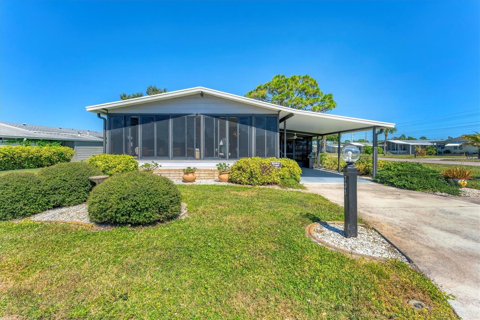 CHARMING TURN-KEY HOME with TROPICAL BREEZES & PALM TREES! Escape the cold & embrace the Florida sunshine you so deserve! This beautifully maintained home has been in the family since 1991 and is fully furnished, and ready for you to move right in. As you arrive, you'll notice the large 12x24 carport, expanded driveway (19x23) which provides ample parking on this oversized corner lot. There's a large (12x26) shed for extra storage. Inside, an open floor plan offers plenty of room for entertaining friends & family, tastefully updated over the years for modern comfort. FEATURES & UPGRADES: FULLY UPDATED KITCHEN - New stove, dishwasher, cabinets & Corian countertops. Upgraded windows, all replaced with single-family home windows (not standard manufactured home windows). STYLISH BATHROOMS: undated counters and an oversized shower in the primary suite. ROOF: New in 2023, oversized hidden gutters, and back flow system in 2024. SPRINKLERS: underground with its own well. FLOORING: Beautifully upgraded laminate wood flooring throughout home. WASHER & DRYER, NEW ENTERTAINMENT READY: Movie projector with wiring included. SPACIOUS LANAI AREAS: Front lanai has special windows with custom shades; side lanai - vinyl replaced windows in 2024, ceiling fans in every room for extra comfort. ELEGANT DINING ROOM MIRROR - high end designed for balanced lighting. This home sits on an oversized lot that you own. Tangerine Woods is an active and friendly neighborhood. You won't feel cramped by your neighbors in this complex. Enjoy incredible amenities such as Olympic sized, heated pool and spa, tennis courts, pickle ball, shuffleboard, walking trails & fitness room. Located just minutes from the shops & restaurants of historic Dearborn Street, world class fishing and many golf courses, this home offers an ideal Florida lifestyle. Schedule your showing today!