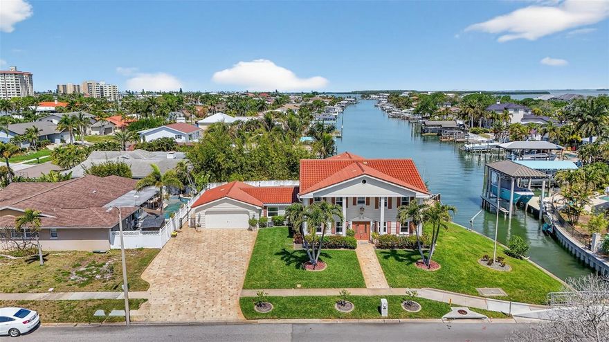 Experience true Florida waterfront living in this elevated lot which had NO FLOODING in last major storms. This beautiful property is a spacious 3,366 sq ft residence featuring 4 bedrooms, 3.5 baths, and a private pool overlooking the water. Light-filled interiors offer generous living and entertaining spaces, including a large kitchen with direct access to the pool deck for seamless indoor-outdoor living. The adjoining dining and living areas are complemented by a versatile bonus space ideal for a home office or additional family room, along with a secondary flex room near the garage. It is a blank canvas ready for you to make your own. The primary suite provides a private retreat with en-suite bath, while upstairs, two guest bedrooms open to a shared balcony—perfect for enjoying coastal breezes and water views. Outdoors, enjoy a private dock with davit lift option, offering easy access to boating, fishing, and sunset cruises. The expansive patio and pool area are ideal for entertaining. An oversized 2-car garage includes a convenient half bath serving the pool area.  A rare opportunity to own a spacious waterfront home in sought-after Island Estates—close to Clearwater Beach, dining, and shopping.