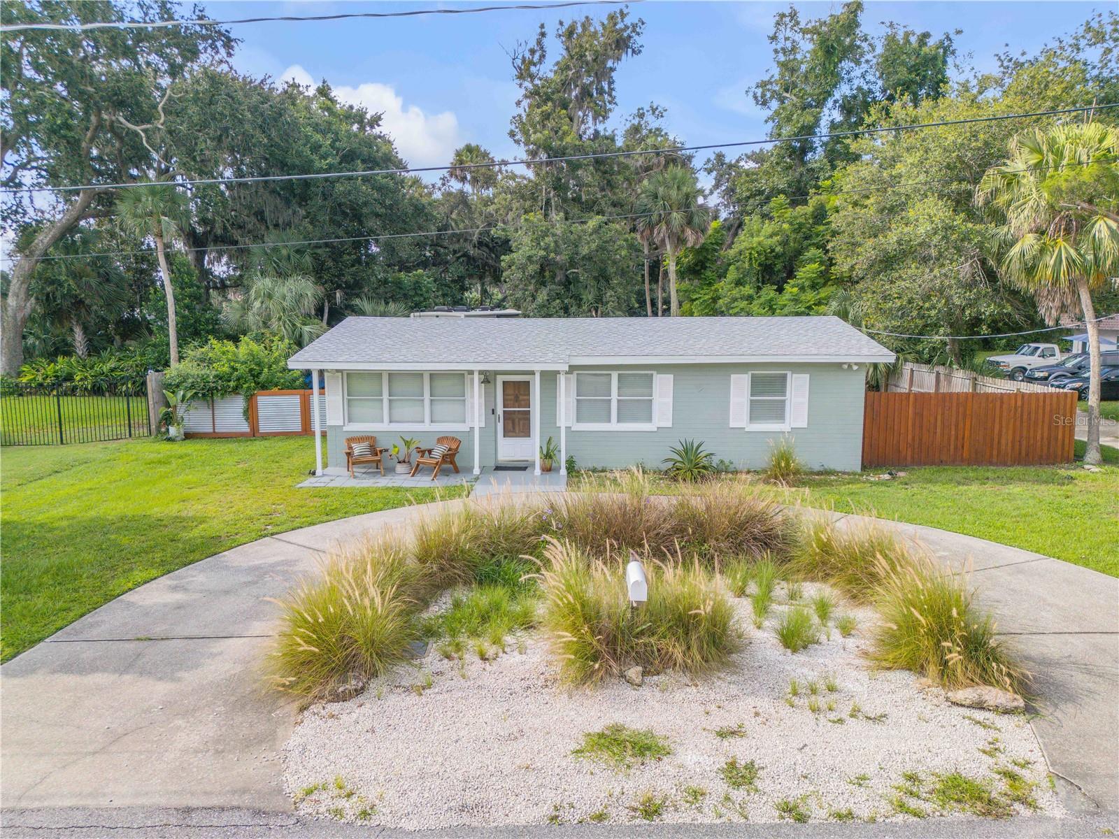 Charming coastal cottage on an oversized lot just steps to the Intracoastal Waterway and minutes to New Smyrna Beach. This solid block home offers the perfect setup for boating and beach enthusiasts, with a public boat launch only a few blocks away and plenty of room to store toys. Hop on a golf cart and be to the beach or exploring Flagler Avenue’s dining, boutiques, and nightlife in less than 10 minutes. Outdoor lovers can walk or bike scenic Riverside Drive to Veterans Memorial Park, where you will find a fishing pier, playground, and picnic pavilions. A screened porch overlooks the shaded, fully fenced backyard, complete with a patio ideal for barbecues and gatherings. Peace of mind comes with recent updates including a 2023 roof, double pane windows, hurricane shutters, and recently installed appliances. Whether you are searching for a full time home or a vacation retreat, this property offers the ultimate New Smyrna Beach lifestyle, close to marinas, golf courses, and just a short drive to Canal Street’s art galleries and restaurants.