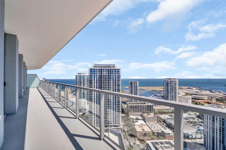 Rising from the 36th floor of the iconic 400 Central, Residence 3606 captures sweeping southeast views of Tampa Bay and the downtown skyline from one of the tower’s most elevated vantage points. From sunrise over open water to shimmering evening city lights, this three-bedroom, three-bath residence offers a rare opportunity to live high above the vibrant heart of downtown St. Petersburg while immersed in panoramic coastal vistas.
Encompassing approximately 1,948 square feet of refined interior living space, the home is complemented by an extraordinary 413-square-foot full-length terrace that spans the width of the residence — creating a seamless indoor-outdoor lifestyle rarely found in a downtown tower. Floor-to-ceiling glass and expansive sliding doors flood the open-concept living and dining areas with natural light while framing uninterrupted water and skyline views.
The thoughtfully designed split-bedroom floor plan offers both privacy and functionality. The spacious owner’s suite enjoys direct terrace access, a generous walk-in closet, and a spa-inspired bath featuring dual vanities, a soaking tub, and a separate glass-enclosed shower. Each guest bedroom is well proportioned and positioned for comfort, making this layout ideal for full-time living or hosting with ease.
The chef’s kitchen anchors the great room and is designed for both everyday living and entertaining, offering sleek cabinetry, premium appliances, and an oversized island that maintains open sightlines to the water beyond.
A dedicated parking space, valet service, and a private climate-controlled storage unit add a level of convenience and security rarely available in a premier downtown high-rise. 
With 2,361 total square feet including terrace space, Residence 3606 delivers scale, flow, and dramatic views at a level rarely available.
400 Central redefines luxury condominium living in downtown St. Petersburg, offering resort-style amenities including a rooftop pool and spa deck, private cabanas, state-of-the-art fitness center, residents’ lounge, concierge services, and secure access — all just steps from Central Avenue’s dining, museums, waterfront parks, and the St. Pete Pier.
Elevated. Refined. Unmistakably iconic.
