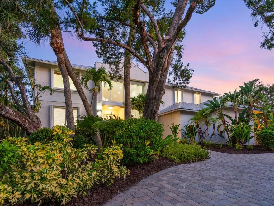 This fabulous home has been repriced to the market. Experience the pinnacle of modern coastal living in this extraordinary four-bedroom-plus-office, four-and-a-half-bath waterfront residence. Ideally located on Siesta Key, on the deep boating water of the Grand Canal, nestled on an oversized, 16,200-square-foot lot on a private street near the renowned white quartz sands of Siesta Key Beach. This stunning contemporary home offers direct access to Sarasota Bay, making it a true haven for water enthusiasts. Upon entering, be captivated by the grandeur of the soaring 20-foot ceilings in the entryway, showcasing a floating staircase adorned with sleek stainless steel rails and cables; this architectural feature sets the tone for the entire home. Enhancing the ambiance, a two-sided fireplace serves as a central focal point, gracing both the living room and family room, boasting floor-to-ceiling walls of windows, which continue to the dining room. The heart of the home is the gourmet island kitchen, a culinary dream equipped with top-of-the-line appliances, granite countertops, and an abundance of storage, complete with a spacious pantry. The main level seamlessly combines entertainment and functionality, boasting a media room and a thoughtfully designed office space. A convenient first-floor bedroom suite adds an element of versatility and convenience. Ascend the staircase to an expansive loft overlooking the lower level, offering additional office space and a quiet reading nook. The master bedroom suite is a true retreat, with waterfront views and a private balcony - a perfect spot to unwind and enjoy a morning coffee and gentle evening breezes. An adjoining sitting room leads to the luxurious master bath, featuring a spa-like ambiance, and a generously sized walk-in closet that will indulge even the most discerning fashion enthusiast. Privacy and comfort define the split bedroom plan, with two additional guest suites on the upper level, each providing an oasis of relaxation and a private en-suite bath. Step outside to the lush outdoor living space, where the waterfront beckons. A private dock offers direct access for boating, fishing, or simply embracing the tranquility of waterfront living. Whether basking in the sun by the poolside, hosting gatherings on the expansive patio, or embarking on nautical adventures by boat, paddleboard, or kayak, every aspect of the Florida lifestyle is beautifully embraced and surrounded by lush tropical gardens. The spacious side-entry garage offers ample room for vehicles and storage, while the generously sized paver driveway and circular drive ensure no shortage of parking spaces for residents and visitors alike. Elevated construction - low flood insurance rate ($1,075/yr.) Close to Siesta Key Village’s unique boutiques and eateries, the Out-of-Door Academy, and minutes over the bridge to Sarasota’s vibrant cultural downtown, entertainment, restaurants, and shopping.