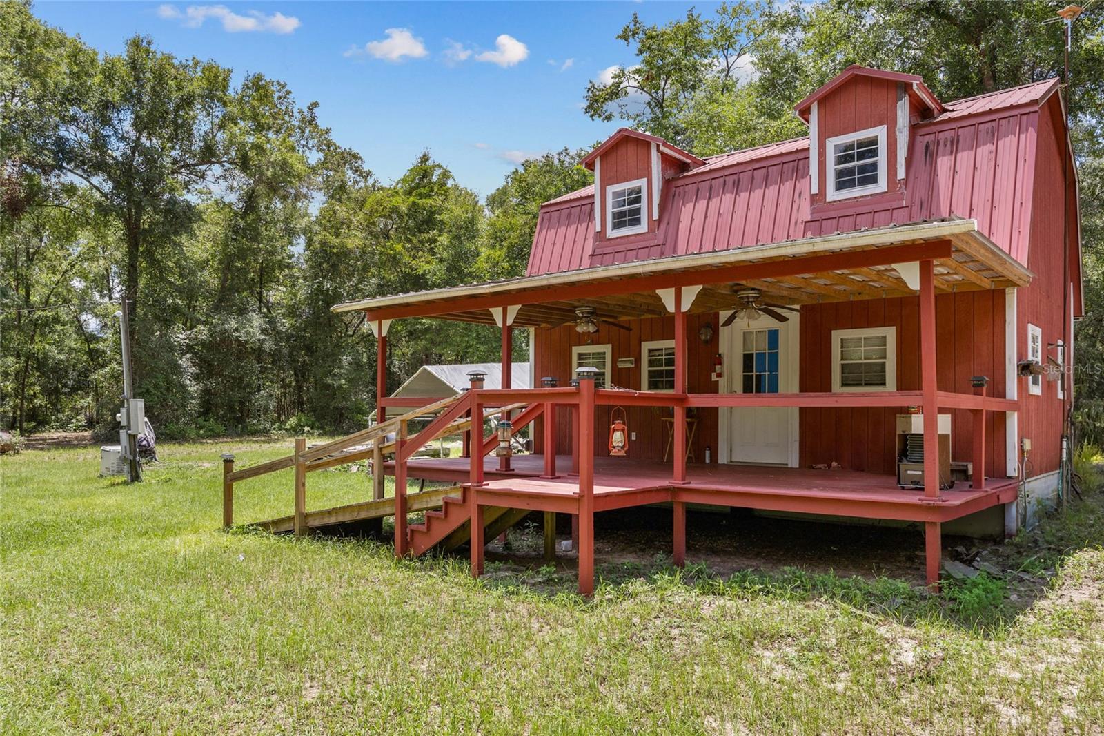 Don’t miss your chance to own 10 unspoiled acres in Fort White that feature an adorable 2-story rustic barn. The 1,005 sq. ft. barn has a 2022 metal roof and covered front porch, and a warm, natural wood interior that includes exposed beams, paneled walls, and custom cabinetry. The front door opens to a kitchen on the left with 2023 appliances and a living room on the right. Rounding out the first floor is a bathroom with walk-in shower. An open staircase takes you up to a large second-floor bedroom with fabulous views. On the porch, additional ceiling fans with lights transform the space into a delightful outdoor retreat. Beyond the barn, you’ll discover a dedicated carport, functional chicken coop, convenient workshop ready for your projects, and a Generac generator as a backup power source. This exceptional property in southern Columbia County offers the ideal blend of fun, adventure, and convenience. Nestled among picturesque timberland, farms, and homesteads, it boasts majestic oaks and pines, teeming with deer, turkeys, and other wildlife. With electricity available, no HOA fees, and favorable Columbia County taxes, this beautiful acreage presents a world of possibilities and is an ideal setting for anything from this cozy, modest barn to a sprawling country estate to a lucrative Airbnb. Its close proximity to downtown Fort White and High Springs means easy access to schools, stores, restaurants, healthcare, entertainment, and adventure. Fort White is an ideal destination for outdoor enthusiasts, thanks to its proximity to three major rivers and various state parks, including the popular Ichetucknee Springs State Park, which is just 4 miles away. While exuding small-town charm, Fort White is conveniently located near major thoroughfares, only two hours from Atlantic beaches, and a little over an hour from the Gulf. Opportunities like this don’t last long, so schedule your private showing today!