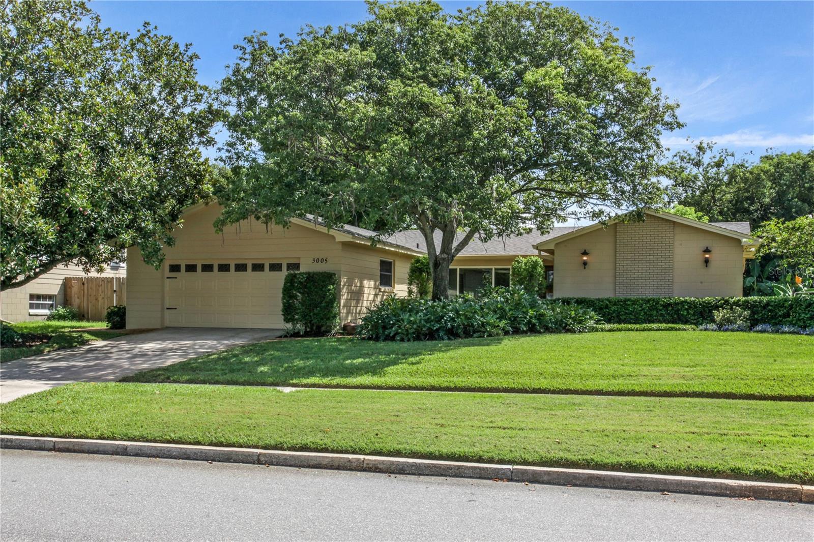 If you have been looking for a turn-key, move in ready home in the SODO/Pershing area, this is it. The current owner fell in love with the natural light that greeted them the first time they opened the front door - 44 years later it is time for this home to welcome its next occupants. The hope is that you are as impressed as they were. This property offers 4 bedrooms, 2 baths in just over 1800 square feet, and sits on just under a quarter acre. From the street, curb appeal is undeniable. The impressive landscaping includes an established Southern Magnolia and a Tabebuia tree that shades the front yard and is a mass of pink trumpet flowers during its spring bloom. Approach the beautiful front door, through the courtyard entry, on the inlaid herringbone brick walk. The light filled foyer offers generous storage in a double coat closet and allows you the option of exploring the living/dining and primary bedroom to the right, or the kitchen/family room and secondary bedrooms to the left. The primary bedroom is generously sized with a dressing area, walk-in closet, en-suite with shower, as well as custom blinds with top down/bottom up feature, ceiling fans, and canned lights. The living and dining room open to the screened patio and large, fenced and landscaped back yard. The kitchen features oak cabinetry, with pop-up mixer cabinet, pull out trash bin, sink front tip outs, 2 stacks of drawers, a lazy susan as well as an undermount sink in the honed leather Silestone counters. A wall pantry, breakfast bar, and all appliances including a French door refrigerator, Bosch dishwasher, GE Advantium convection/microwave oven and smooth cooktop range complete the kitchen. The family room window overlooks the front courtyard through a hurricane impact window. Other windows are double paned, double hung in baths, kitchen and garage and have plywood panels with hurricane clips. The three secondary bedrooms are all generously sized. The oversized garage features a 2" insulated Clopay garage door, garage door opener, and side access utility door. The back screened porch welcomes you out to enjoy the lovely back yard. Keep the air moving with the remote controlled, wall mounted fan. If you love the scent of jasmine, you will appreciate the confederate jasmine that covers the north fence. The rear fence is the SimTeck Ashland extruded panel in Walnut. It is beautiful and maintenance free. What else?... Architectural shingle roof (05/2023), replumbed (03/2022), 16 SEER Amana A/C Heat pump system (05/2022), Updated electrical panel, New well pump (2024), Full irrigation system, New exterior paint (08/2025), New interior paint (08/2025), Solid wood 6 panel interior doors, 5 inch baseboards, upgraded door casings, core-foam insulation in exterior block walls, New bedroom carpet (08/2025), Contemporary ceiling fans, fresh cabinet and door hardware, 2.5 inch no cord blinds in secondary bedrooms. Might there be something you'd like to change? Possibly. Is there something you'd have to change to live graciously in this home? Not likely. The location is super convenient to the bustling SODO area, downtown Orlando, the Orlando International Airport, I4, 408, and the 528. Down the street is Orange County's Fort Gatlin Recreation Center with a great pool and tennis courts. Annual memberships are available for $60/person or $2/person/day. Schools are currently zoned for Pershing K-8 and Boone High School. It is time to take a look.