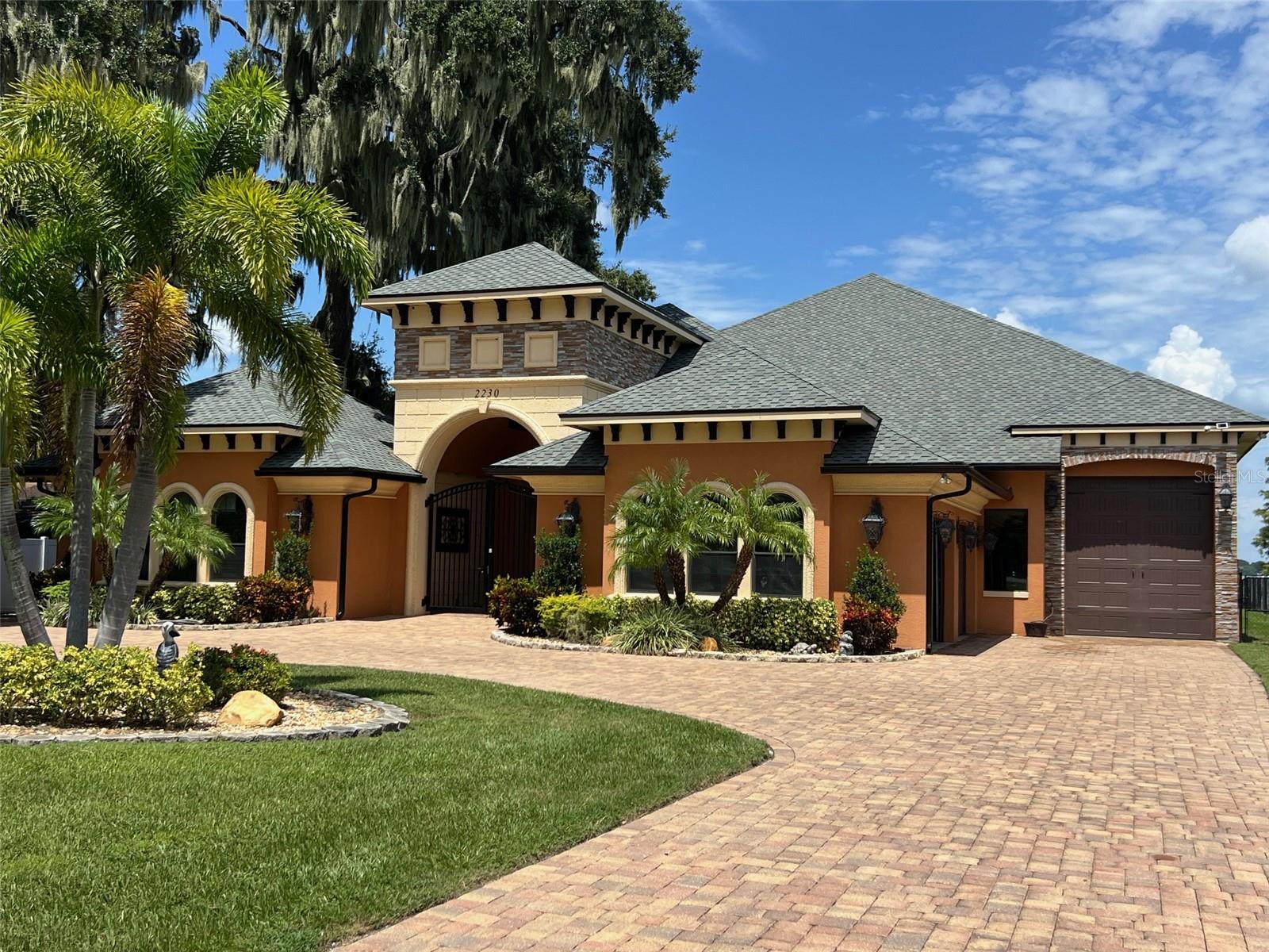 Florida boater's dream come true! THE LUXURIOUS LAKEFRONT PARADISE that everyone has admired and wished for is finally on the market! NO HOA! Check out this Stunning CUSTOM BUILT 4 BDRM 3 1/2 Bath situated on .76 acre of waterfront tranquility on beautiful LAKE ARIANA. BONUS the property also includes a SEPARATE SIDE CABANA SUITE that grants stylish independence, live-in relative housekeeper, Nanny or simply to provide privacy for your GUESTS. Notice the impressive long paved circle driveway that can accommodate plenty of parking w/lush landscaping. Walk through the gated grand entrance and you are welcomed by your very own tropical oasis in an open atrium allowing you to create a relaxed area for friends and family to unwind around the pool with access to the half bath. Step inside the tall iron arched double front doors and be amazed by a grand great room with voluminous vaulted ceilings, tile/wood flooring, glass windows offering an abundance of natural lighting and the most breathtaking views of the huge backyard and lake. Endless custom built details featuring unmatchable interior woodwork and more! Open gourmet chef’s kitchen has state of the art cooking capability, equipped w/Subzero Refrigerator and separate wine cooler. Gas 6 burner WOLF RANGE/OVEN, Bosch dishwasher and bar refrigerator making this home fabulous for entertaining. Granite countertops and cabinets add lots of space and seating room for casual bites at the bar or at the breakfast nook's charming banquette. Adjoining family room perfect for a large gathering with sliding glass doors that opens to the pool & courtyard. If LUXURY is what you seek, the MASTER EN SUITE will not disappoint. Wake up with a spectacular view and open up the french doors and let the sunshine in with access to the lanai. Master bath has grand soaking tub, dual vanities, Hollywood luxury lights, walk-in shower and you will love the deep walk in closet to organize all your personal items. Make your way up the grand staircase, a separate world beckons family or guests! BDRM#1 can also be used as a flex area for gaming or relaxing w/panoramic views, a barn door provides privacy with a balcony that overlooks the great room below. BDRM#3 features a hidden storage area that can be used as a play area. BDRM#2 has built-in THEATER ROOM. 2 utility rooms for laundry. The CABANA SUITE has private side entrance, full kitchen w/breakfast bar, living room, 1 BDRM, 1 bath and stackable washer/dryer. The Outdoor lanai encompasses the width of the home w/columns ready to add a custom screen enclosure or outdoor kitchen. LOVE FISHING, JET SKIING or PEACEFUL BOAT RIDES? Imagine lakefront living, making every day feel like a vacation. Have a RV, BOAT, Jet skis, or extra vehicles? The oversized separate 3rd garage w/high entry and exit garage bay doors provide a dedicated spot to park and passthrough to the lake and could be expanded. True quality and craftsmanship with so many custom details to list them all here. Lovingly maintained and shows pride of ownership. Located in the heart of the Sunshine State, centrally between Greater Tampa Bay/Disney Orlando and Coast to Coast via I-4 and Polk Parkway!