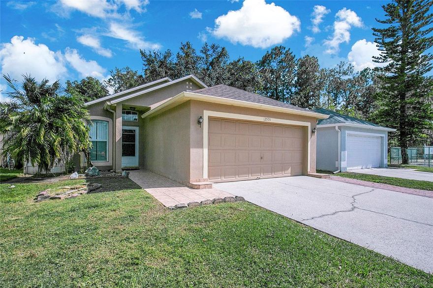With no rear neighbors and a fully fenced backyard, this 3-bedroom, 2-bath home offers the privacy you want in a location that’s hard to beat. Step inside to a bright, open layout with tile flooring throughout—low maintenance and perfect for everyday living. The kitchen sits at the heart of the home, offering plenty of cabinet storage and an easy flow into the dining area. The spacious living room features high ceilings and sliders that open to the large paver patio—ideal for grilling out or relaxing in your own private outdoor space. Down the hall, you’ll find the primary bedroom with its own ensuite bath, along with two additional bedrooms and a full hallway bathroom. The interior laundry room adds everyday convenience, and the two-car garage provides extra storage and parking. Outside, you’ll love the peaceful backdrop with no rear neighbors, and the community green space with a basketball court just a few lots down. Location is everything here—just minutes to UCF, Siemens, and Waterford Lakes Town Center, with easy access to SR-408, SR-417, and Colonial Drive for commuting, shopping, and dining. Whether you’re a first-time buyer, investor, or looking to downsize, this home checks all the right boxes in one of East Orlando’s most convenient spots.
