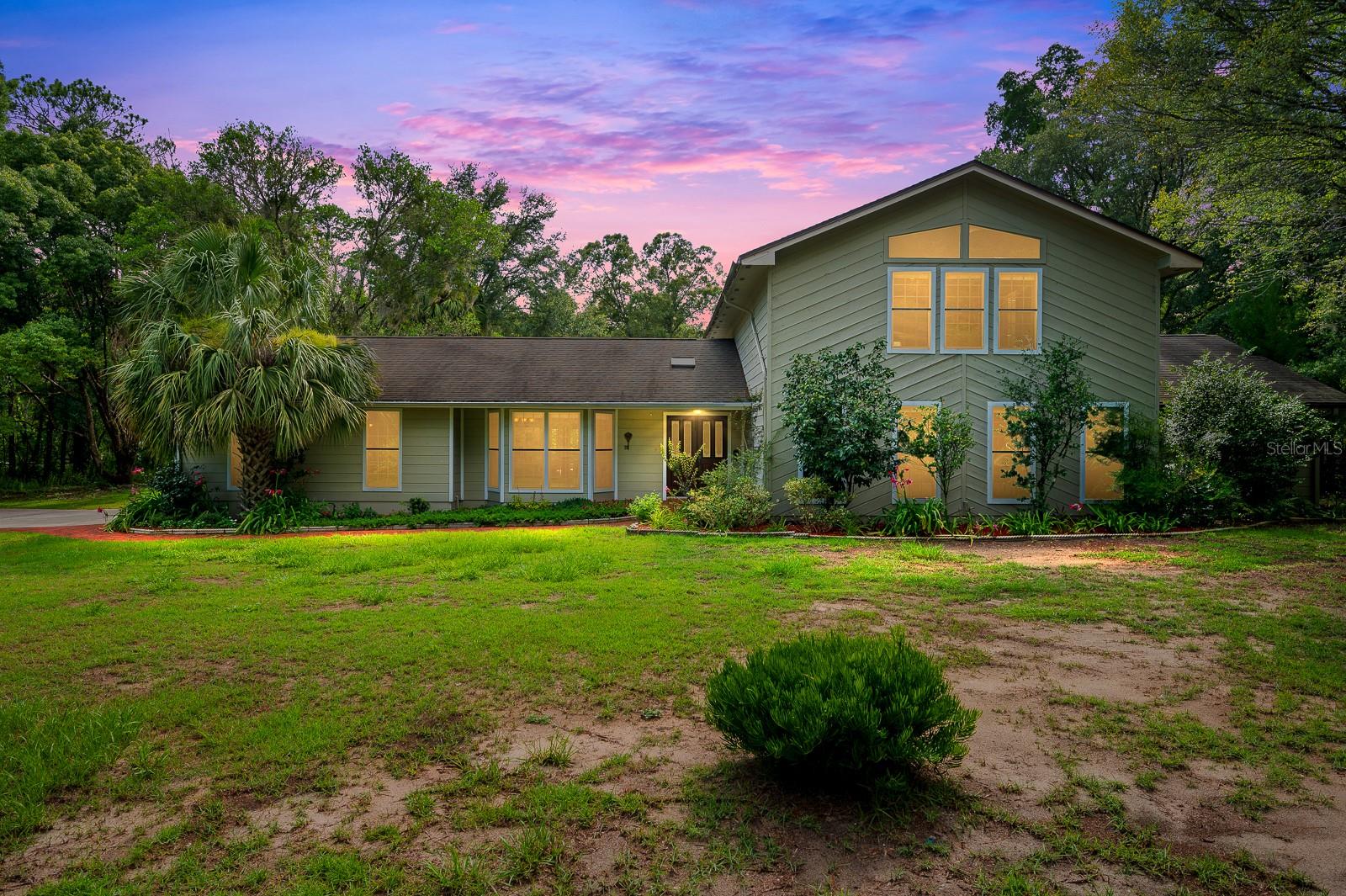 Located just outside the Gainesville city limits, this beautifully crafted solid cedar wood home, built in 1984, offers a rare combination of privacy, natural beauty, and convenience. Set on 4.42 acres in a community of custom-built homes on oversized lots, the property also includes access to scenic neighborhood trails, ideal for quiet walks and enjoying the outdoors. All of this just 15 minutes from UF, Shands, the VA, and close to shopping and dining. The home offers 2,840 square feet of living space, with 3 bedrooms and 3 full bathrooms, including a Jack-and-Jill bath. A spacious upstairs loft with a full bath and walk-in closet provides flexible use for a home office, playroom, or guest area. The main living room is filled with natural light and features dramatic vaulted ceilings, while the kitchen and primary bathroom are appointed with granite countertops. Hardwood floors in the living area and primary bedroom add warmth and charm, and a set of French doors serves as a welcoming entrance into the home’s inviting interior. The outdoor living experience is equally impressive. A large screened-in porch with a hot tub offers space for relaxing or entertaining, and a private pool just beyond is surrounded by open sky and mature landscaping. The property also features an artificial pond with a custom-designed rock waterfall, creating a peaceful backdrop that attracts a local family of deer. A detached shed offers practical storage for tools and yard equipment. This well-maintained and thoughtfully designed home presents a rare opportunity to enjoy space, serenity, and timeless craftsmanship—all within easy reach of everything Gainesville has.