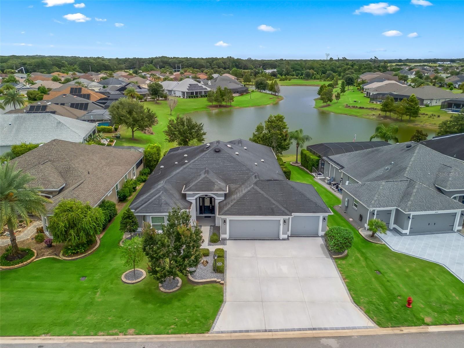 BOND PAID. LAKE FRONT. Nestled in the highly desirable area, the Village of Pine Ridge. Exceptional views of the LAKE SANCTUARY, enjoy a cup of coffee while savoring the Sun Rise and enjoying the Wildlife and bird watching an Eagles Nest. This exquisite DESIGNER LAUREL OAK home features 3 bedrooms and 2 bathrooms, offering over 2,400+ sq ft + 660sq ft in Addition Living Space. Thoughtful design and impeccable taste. The DESIGNER OPEN CONCEPT layout is filled with Natural Light, 10’ft CEILINGS, enhanced by (9) SOLAR TUBES, CUSTOM LIGHTING, CROWN MOLDING, and CUSTOM CORNICE with WOODEN BLINDS. Numerous Ceiling Fans keep the home breezy and comfortable. The layout flows effortlessly to the Additional 660 sq. ft. SUNROOM, with all Glass Slider Doors, AUTOMATIC CUSTOM SHADES, equipped with air conditioning, CEILING FANS, CUSTOM LIGHTING and attached is the open BIRDCAGE with CUSTOM PAINTED Flooring and a 220 Volt Outlet ready for a Hot Tub perfect for outdoor enjoyment. The BUILT IN ENTERTAINMENT system creates a central gathering space in the Living Room, making it perfect for family and friends. The Chef's Kitchen boasts generous counter space, QUARTZ countertops, PANTRY with PULL OUT DRAWERS, BOSCH STAINLESS STEEL APPLIANCES with a MODERN RANGE HOOD, PULL OUT DRAWERS throughout SOFT CLOSE CABINETS, CUSTOM WINE RACK this home is ready for entertaining. Plenty of Space for your guest with a BREAKFAST BAR, EAT IN KITCHEN and FORMAL DINING ROOM, perfect for those special occasions. The home features WOOD LOOK-TILE flooring throughout, with Carpeting in two of the three bedrooms. The Primary Bedroom is a perfect split plan, providing a sense of privacy. It features VAULTED CEILING, VIEWS OF THE LAKE, Ceiling Fan, Carpet, Large WALK IN CLOSET with BUILT IN SHELVING and a spacious EN-SUITE BATHROOM, ROMAN SHOWER, Dual Vanities, Quartz Countertop with ample cabinet space, including a Private Water Closet and Bidet Toilet. Guest Bedroom #2 has TRAY CEILING, BAY WINDOWS, MURPHY BED, CUSTOM CLOSET, Ceiling Fan and Wood-Look Tile Floors. Guest Bedroom #3 has Carpet flooring, ceiling fan and CUSTOM CLOSET. Guest Bathroom is conveniently located and has Tile Shower/Tub Combo, Spacious Vanity with Quartz countertop. This home has lots of Storage from COAT CLOSET to LINEN CLOSETS, to the LAUNDRY ROOM with Added Storage, Wash Sink, and Desk. The (3) CAR GARAGE has 2 Ceiling Fans, Storage, EPOXY Flooring, a CUSTOM PAINTED DRIVEWAY, with Exceptional Lush Landscaping with STACKED PAVERS, and GUTTERS & IRRIGATION. The 2 Car Garage Door has a Automatic Screen for added Privacy. ATTIC has Pull Downstairs, (2) SOLAR POWERED FANS, and extra INSULATION focusing on energy efficiency, comfort, and cost savings. Additional this home includes a SECURITY SYSTEM and KEYLESS Digital Door Locks, Water Filtration System, and all COPPER LIGHTENING RODS. The Moyer Recreation Center/Pool & Pine Ridge Pool/Mail Center is located just (3) minutes from this location and is a community hub focused on promoting health and wellness for residents and visitors alike. The Active Lifestyle offers walking paths near the Sharon Rose Weichens Preserve, tennis, pickleball, and water activities. A short golf cart drive away from BROWNWOOD TOWN SQUARE plus all the conveniences of shopping, Walmart Neighborhood Market, restaurants, and medical facilities. This is a rare opportunity to own this spectacular home in the highly desirable area of the Village of Pine Ridge.