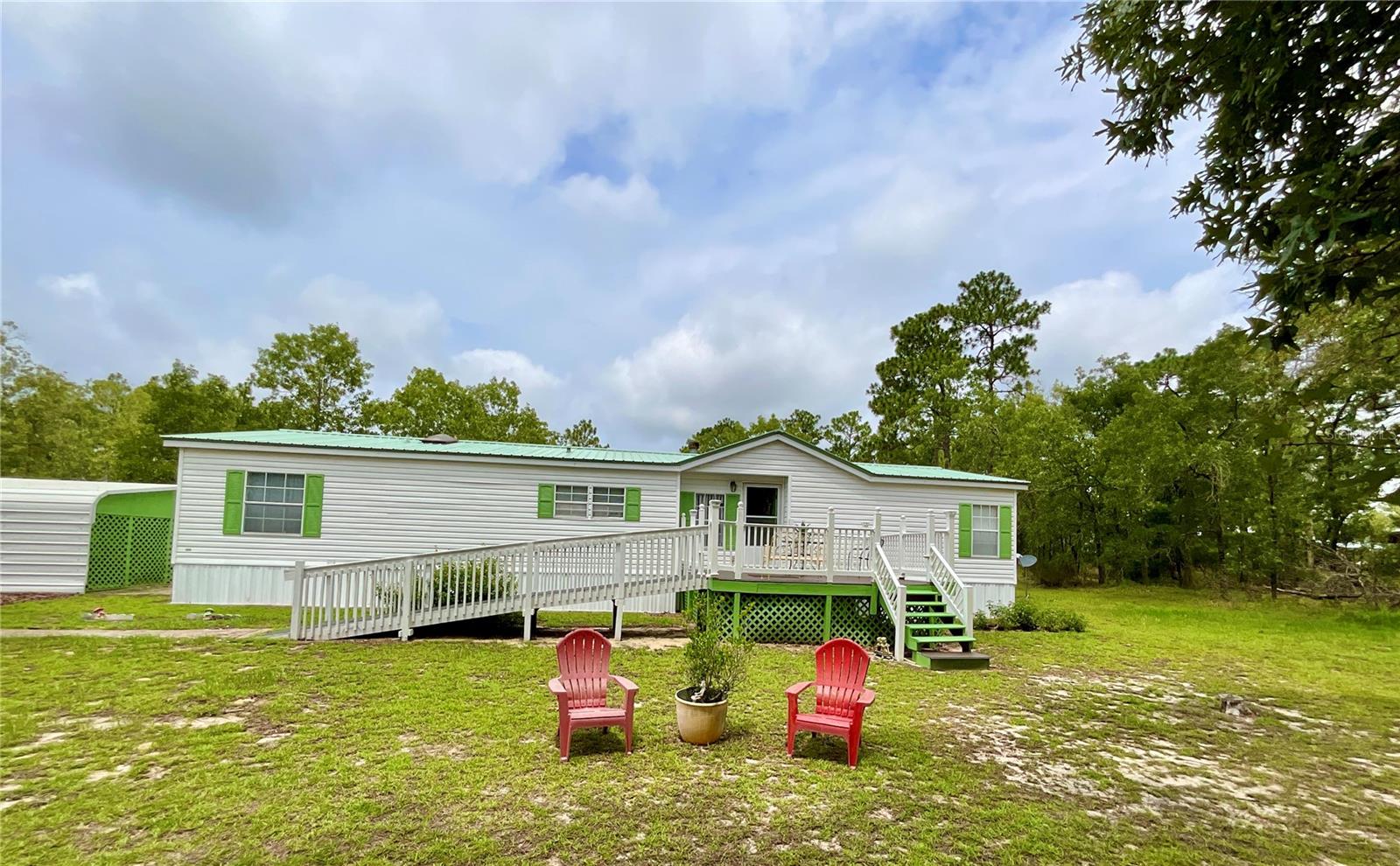 HOME WITH FIVE ACRES ON PRIVATE AIRPORT AT MELROSE LANDING WITH PAVED RUNWAY NEAR HISTORIC MELROSE FLORIDA. The private airport features 3200' lighted paved runway with a 1200' sod-over, and a member community center. This spacious 3/2 1719 SqFt HOMES of MERIT is move in ready. The split open floor plan is wheel chair accessible with over sized doors, and has a new composite deck with Handicap Ramp. Other features include: metal roof, new AC System, fireplace, a roomy practical kitchen with separate dining area, laundry room, 2 car carport and large storage building. ALSO, this home may could come furnished! The 5 acres is partially cleared and has a tie down area for plane and 259 feet fronting the Taxi Way. So whether you fly, have big hobbies needing lots of room or just wanting some good ole rural country living, then this is the place it could all happen for you. In Melrose you'll find only one traffic light but this friendly little town has restaurants, grocery stores, shopping, lots of live music, Senior Center, doctors, farmers market, library, art shops, music store and our beautiful pristine 6000 acre Santa Fe Lake for all your recreational pleasures, swimming, wake surfing, kayaking, skiing, sailing and more. This location is also an easy commute to Gainesville, Palatka, Starke and Ocala Florida. Fly in or drive over to see what a different way of life it is out here in Rural America. For more airport and local info go too: www.Melroselanding.org and www.historicmelrose.com. Note: Photos include some around town pictures