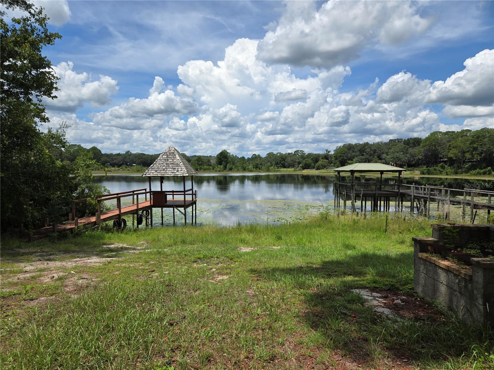 This waterfront house is ready for a new owner. Huge 2 story home could be multi-family setup up or short term AirBNB rental. The main floor is a 3/2 with a huge living room w/ fireplace, 2 car garage. Huge deck overlooking the lake. Large u shaped kitchen with lots of cabinet space.
The downstairs has a 3 bedroom 1 bath with a kitchenette, living room & large patio overlooking the lake. A spiral staircase connects the main & second floor.
Home is situated high on a hill with a dock for fishing.
