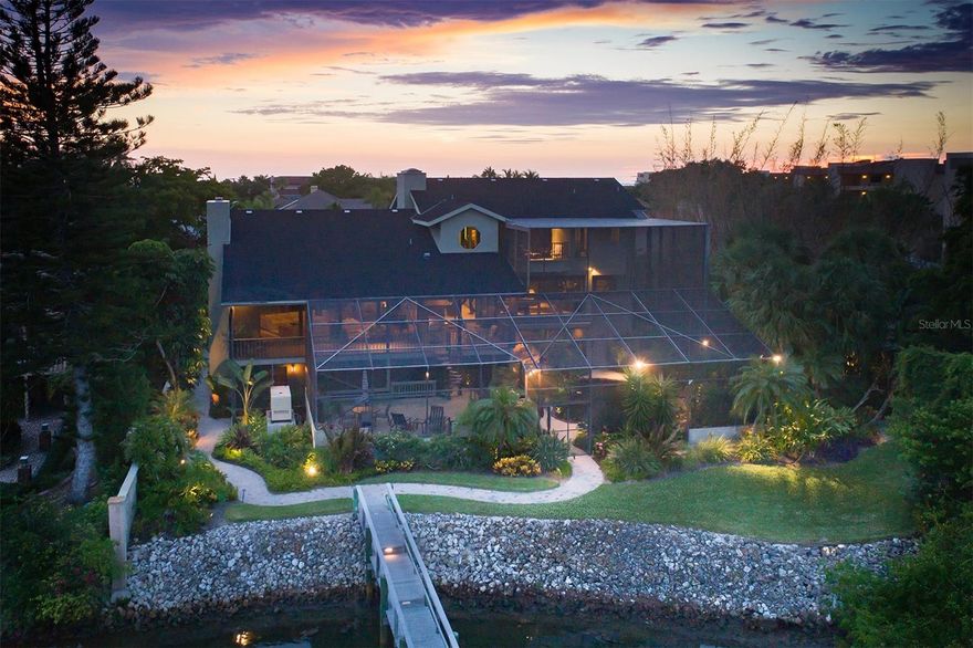 Nestled on the desirable quiet south end of Siesta Key is this lovely 3 story home.  When you walk through the front gates you immediately hear the calming sounds of water from a nearby water feature. You step inside the front door and your eyes are drawn to the top of the winding staircase that leads to the second floor.  Once you reach the top of those stairs, you want to look at the large dining room with its table seating 12 or the grandness of the living room with the vaulted ceiling and fireplace but the wall of windows has grabbed your attention.  Like a giant piece of artwork, the Little Sarasota Bay and ICW are displayed for your daily view.  You immediately start thinking of all the fun activities you can do...boating, jet skiing, paddle boarding, fishing...all right there for your enjoyment.  When all this sinks in, you start to look at the inside surroundings.  The openness and flow from the dining room or living into the kitchen brings thoughts of parties and family gatherings.  The kitchen, which has two Wolff convection ovens, a cooktop with hood, Subzero refrigerator, Scotsman ice machine, and instant hot water dispenser brings out your inner chef!.  Off of the kitchen is a cozy family room.  There is a bathroom just off the family room which is connected to a large bedroom with walk in closet.  The second floor also has the laundry room and a half bath.  Take the stairs or elevator just outside of the laundry room up to the Primary level.  There you will find a massive bedroom with a sitting area overlooking the balcony pool and the bay.  Not one, but two primary bathrooms are on this floor along with two walk in closets, one of which is so large any fashionista would love to call it their own.  Now let's explore the first floor where you will find a huge great room with multi-sliders that open up to indoor/outdoor living.   You will look out into a beautifully lush oasis with a lagoon style pool.  Off of the great room is a bedroom with an en suite bathroom that also serves as the pool bath with an entrance from outside.  The split floor plan has a library with two bedrooms and a bath on the opposite side of the house with access to the pool from the library.  There are multiple decks at this home for you to sit back and relax.  There is a dock that has electricity and water and a 10,000 lb lift for your boat.  And if you're feeling like a stroll, walk over to the deeded access beach and enjoy a sunset or two.  Paradise awaits, come and see for yourself.