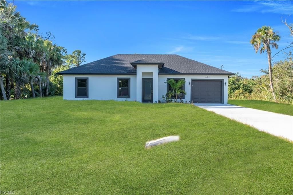 Photo of 644 Woodcrest Dr, Lehigh Acres, FL 33972 (MLS # TB8499934)
