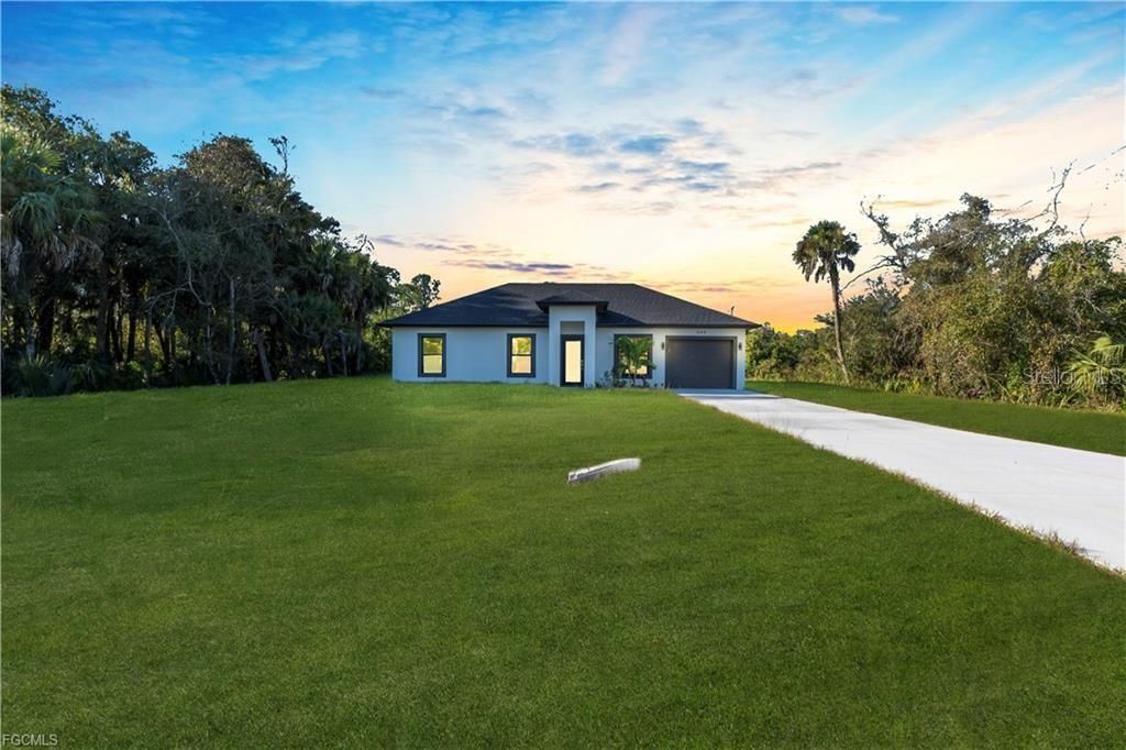 Photo of 644 Woodcrest Dr, Lehigh Acres, FL 33972 (MLS # TB8499934)
