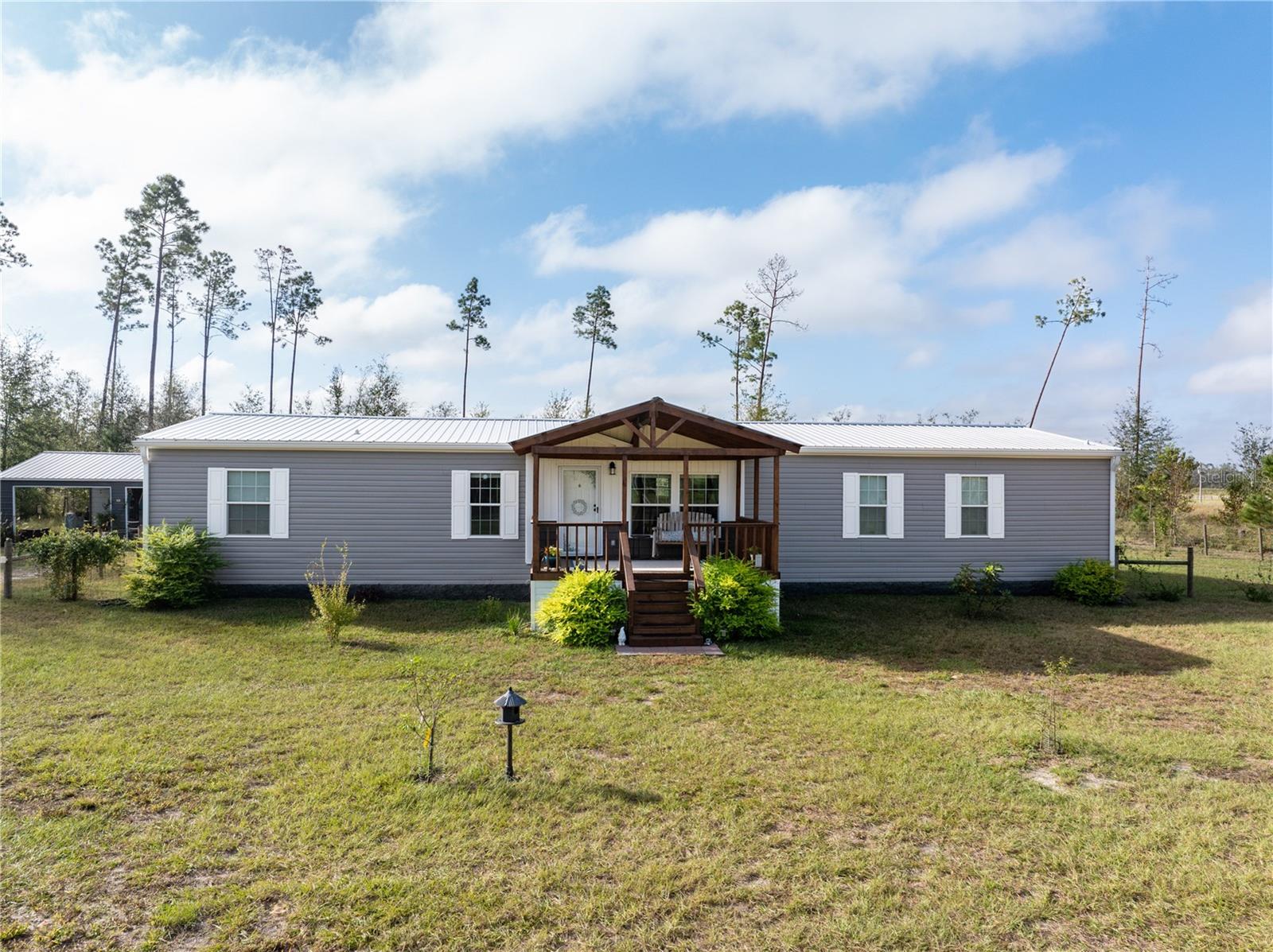 Remarkable 5-Bedroom Home on 5 Acres Near the Suwannee River. Discover this beautifully maintained, like-new 5-bedroom, 3-bath home (one Jack n Jill), perfectly set off the road on a peaceful 5-acre lot. Enjoy the serenity of the countryside with conveniences just minutes away in Dowling Park. It is also convenient to the Suwannee River while remaining safely outside flood zones. Indoors you will fall in love with the bright, open space and the huge breakfast bar. A cozy family room with a built-in entertainment center is perfect for movie nights. Outdoors, this home boasts a fenced backyard ideal for pets or outdoor activities like the existing Bocce/Horseshoe court. The spacious open back deck is perfect for relaxing or entertaining, and a charming covered front porch to enjoy the views. A detached 2-car carport, currently used for entertaining, offers even more flexibility for gatherings. There's a greenhouse for the garden enthusiast, raised beds, and several fruit trees are in place. Additional storage is no issue with a large shed on the property. This is a rare opportunity to own a private retreat, offering plenty of space inside and out.