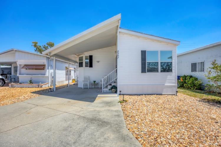 Beautiful and spacious 2/2 double wide home in sought after Trailer Estates. Trailer Estates is a 55+ Water Front Community with so many amenities and you own the land. No rent. This home has all newer stainless appliances, newer flooring, newer bedroom carpets and newer furniture 2022. High ceilings and comes turnkey furnished. The Kitchen consists of new Stainless appliances and a breakfast bar which is open to the dining room. Great for dinner gatherings. The spacious living room has sliding doors to the Florida room. The Florida room is great for entertaining, games, and cards. The master bedroom has an ensuite bathroom with shower. This home also has a guest bedroom and guest bathroom with a tub and shower. There is a shed out back with a workshop, and sitting area. There is also a sitting area under the carport out front. There is a 1 car carport and plenty of parking. This home has not had any hurricane, storm damage. Trailer Estates has so many amenities. A very large pool, spa, woodshop, park on the water, marina, kayak launch and storage, fitness center, their own post office, club house, pickle ball, a storage lot and so much more plus many activities. Close to shopping, restaurants, SRQ airport and beaches.