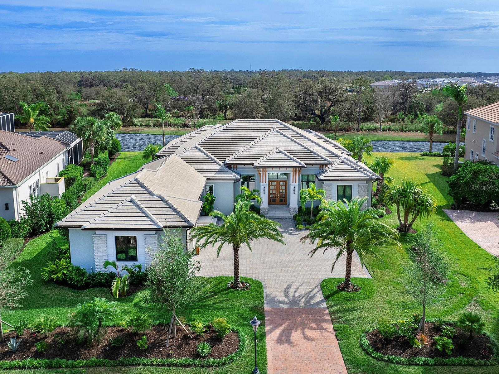 There is only one Founders Club, and there is nothing ordinary about the private, elegant, upscale environment that this 24-hour guard-gated community is known for. Just 262 homes make up this desirable, exclusive enclave on 762 lush green acres, convenient to all of Lakewood Ranch and Sarasota while remaining quiet and peaceful. Built in 2023 is this gorgeous 3,507 square foot custom home built by local builder, Lee Wetherington. The ideal combination of thoughtful design, contemporary features and comfortable, expansive living spaces. The Smoked European White Oak floors flow seamlessly from room to room. Stunning designer lighting fixtures, custom window and wall treatments, the finest quality finishes and fixtures, recessed lighting, impact windows and solid wood doors are utilized throughout the home. The creatively designed layout of this very special home takes full advantage of the ample natural light and beautiful outside views, with an open floor plan, large windows and high ceilings. From the Great Room, sliding glass doors lead to the 2,300 sq. ft. south-facing, screened lanai - a luxury resort onto itself, providing tranquility and relaxation for the homeowners and the perfect party space to entertain guests, with a fully equipped outdoor kitchen, electric heated pool and spill-edge spa. Both home cooks and professional chefs will appreciate this well thought out kitchen, stainless-steel Bosch appliances, Sub Zero refrigerator, walk-in pantry with solid wood shelving and sleek modern cabinetry. The kitchen, with its huge window and large format Italian porcelain tile backsplash, opens onto the casual dining space and wine bar area with wine refrigerator and additional cabinetry. The more formal dining area has a striking chandelier, custom mirrored accent wall and shares the dual-sided glass display cabinets with the kitchen area wine bar creating a convenient pass-through from wine service to dining. Vestibule doors lead to the primary bedroom wing, constructed with mineral wool sound mitigation inside the shared entertaining-area walls for additional soundproofing, as well as floor-to-ceiling windows and a glass door opening to the lanai. The tailormade “dream” closet, is substantial in size and aesthetically pleasing to the eyes with an upscale closet organization system. The spa-like master bath has a walk-in frameless shower, oversized soaking tub, separate water closet, makeup vanity, lighted mirrors, Lunada Bay handcrafted tiles and Cambria countertops to round out this indulgent retreat. There are two beautifully equipped guest suites, each with custom shades, frameless shower enclosures and contemporary lighting fixtures and cabinetry. Both guest suites open onto the courtyard Zen Garden, the ideal private space for your guests to enjoy morning coffee or an evening cocktail. For added convenience, there is an 89 square foot air-conditioned Florida basement, providing the ideal extra-storage space as well as a full-size refrigerator. The home is built for secure living, in addition to the impact windows and doors throughout there is a 26kw whole house generator. This residence provides beauty, privacy, exclusivity, safety and a premier location – the best of Florida living, inside and outside. It is truly one of a kind and only 15 minutes from Downtown Sarasota. Optional memberships are available at the Founders Golf Club offering golf, tennis, fitness, Pilates & yoga, massage therapy and dining.