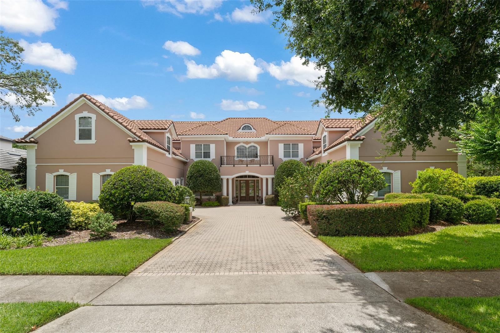 Classic elegance defined in this stately mansion boasting 8 bedrooms, two bonus rooms, luxurious grand living spaces, and two 2-car garages, located on the pristine Butler Chain of Lakes in guard-gated Turtle Creek. This Dr. Phillips estate has never been offered to the market before and offers traditional opulence combined with refined style and grace. The welcoming entrance sets the stage for gatherings of any size with a lovely formal living room, distinguished dining room, butler’s pantry, and grand kitchen with double islands, cooktop, two sinks, double ovens, and microwave – flowing seamlessly into a large breakfast nook and family room. The family room is framed by double doors overlooking and providing access to the screened pool and spa and summer kitchen. Also on the first floor is a guest suite, den, and primary bedroom wing – complete with morning bar, double vanities, double closets, jetted tub, separate shower, and sumptuous master bedroom with French doors to the pool. Upstairs are 6 additional bedrooms – either ensuite or with a shared “jack-and-jill” bathroom. Two bonus rooms include a large media or second floor family room plus an additional room over one of the two-car garages that could be a ninth bedroom with the addition of a closet. The enormous pool enclosure encapsulates a mammoth swimming pool with an abundance of patio decking, plus a covered summer kitchen patio area for alfresco dining or summer BBQs. A shared covered boat dock lowers with the touch of a button to provide near-instant access to the Butler Chain of Lakes through a private canal, ensuring peace and privacy. A graceful estate for the ages, lovingly cared for since it was completed, and ready to entertain for generations to come. Turtle Creek features a 24-hour on-site guarded entrance, located minutes away from Walt Disney World®, SeaWorld, and Universal Orlando – supremely close to hospitals, Restaurant Row, and offering easy access to Orlando International Airport, the Mall at Millenia, and downtown Orlando.
