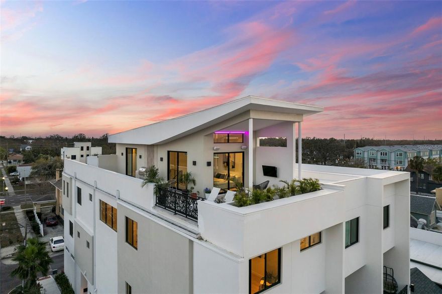 Welcome to an unparalleled urban oasis in St. Petersburg, FL. This 4,800 sq. ft. this Tribeca-style loft condominium offers three bedrooms, three full bathrooms, and two half bathrooms, including  a separate ADU ideal for guests or a home office. This new construction home was built in 2024 by MTBH Studios, St Pete's premier modern luxury design team and builder. The entire home comes optionally immaculately furnished with curated furniture and walls decorated with works from local artists.  Immerse yourself in a world of luxury and sophistication, where soaring 30 ft ceilings flood the space with abundant light, creating art gallery-quality environments.
High-end finishes grace every corner, from Porcelanosa countertops to elegant bathrooms, all centered around a cozy fireplace that exudes modern charm. The gourmet kitchen features a Gaggenau appliance suite with a induction range with downdraft vent, double steam oven, speed oven, microwave/convection combo oven, dishwasher, and paneled fridge and freezer. Private 2nd floor balcony off the living room overlooks Central Avenues live oak trees, fabulous restaurants like Baba, Wildchild, Slim Charmer, and Bandit coffeeshop. The separate third-floor loft media room, complete with a wet bar, wine fridge, surround sound, and half bathroom, is perfect for entertaining and stunning views of downtown St Pete highrises and nearby Tropicana Feild. All 4 floors are accessible by a home elevator that takes you from the garage level up to the roof top.

Smart home features include WAC 4" lighting and sound speakers throughout, all easily controlled from your smartphone. Floating stairs lead to a spectacular rooftop retreat , expansive private roof deck, replete with an outdoor kitchen and a platform ready for a soaking tub, all offering panoramic views of St. Pete.

With a two-car garage with epoxy floors and a street entrance, this townhome provides both convenience and privacy. Located in the vibrant Grand Central District, you're in the heart of St. Petersburg's best dining, art, music, and entertainment scene, with the Gulf beaches just minutes away. Experience single-family home luxury with the low-maintenance benefits of a condominium and a low HOA. Your sophisticated urban retreat awaits!