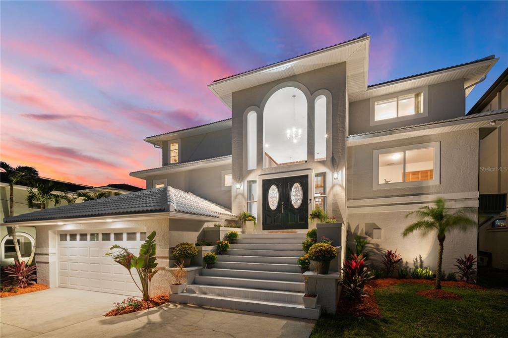WATERFRONT HOME with a BRAND NEW SALT WATER POOL that is just being finished, NEW Westlake Saxony 900 slate ultra-white roof tile being installed. Ground floor features 1806SF of finished space that is not included on public records! This lovely home features 5 bedrooms, 3.5 bathrooms & is located on a quiet street that is just a few minute walk or Golf Cart ride to the Famous Clearwater Beach. This waterfront Estate features incredible water views from every room & at night you will love the lights as the reflect on the water & the views of the Sand Key Bridge that is all lit up! As you walk up to the home you will notice all the large windows that let in tons of natural light! Once you enter the the double front doors you will love the open concept living, tons of natural light, high vaulted ceilings, & the large family room that opens to the kitchen. The kitchen features a large center island with extra storage, room for bar stools, stainless steel appliances & from the eat in area you will have water views from the 2 large windows. From the sliding glass doors that are just off the family room you can enjoy the direct water views & views of the sand key bridge that overlooks the beautiful intercoastal waterways. From any of the 3 balconies you can enjoy not only the water views but also the endless sunsets! The main level has two bedrooms, one of which could be used as an office & the other one has a large walk-in closet plus 1.5 baths. Separate laundry room with lots of storage & access to stairs leading down to the garage & bonus room.The living space on the main floor features 24 x 24 porcelain tile flooring & all of the bedrooms have beautiful wood floors. As you head upstairs you will love the open staircase & area where you can see the water from both sides of the house and on the landing is a great reading nook with open views to the main level. On this level you will find the owners retreat plus two guest bedrooms, one of which has its own private balcony, & 2 full baths. From the balconies you can enjoy your morning cup of coffee while watching the dolphins & boats as they come & go or enjoy a glass of wine while enjoying the sunsets or night views. The large owners retreat features sliders out to your private balcony, large walk-in closet, en suite with garden tub, large walk-in shower, 2 vessel sinks & lots of storage. Once you go to the lower level you will find the finished 1,800 sq. ft. bonus room with A/C, travertine floors & sliding doors that lead outside to your new backyard oasis. The owners have spared no expense on this new outdoor living space that will include a new pool, upgraded pool deck with Italian marble, spill over spa, LED lighted sheer decent waterfall with an 8-9 ft fire feature, gas & electric heater that is controllable remotely, outdoor kitchen with blaze grill & fenced in yard. A new sea wall has also just been installed and there is plenty of room to add a boat lift to the DEEP WATER dock. Other recent upgrades include new electrical panels, New LED lighting & freshly painted bathrooms. This property is a short walk to the world-famous Clearwater Beach, Clearwater Marine Aquarium which was the story behind the Dolphin Tail movie & also where the movie was filmed, restaurants, shops, marina, pier 60, & all beach activities. Easy drive to Tampa airport and all Tampa Bay attractions or an easy drive to Downtown areas of St Pete, Clearwater or Tampa. This home is a must see & will not disappoint!