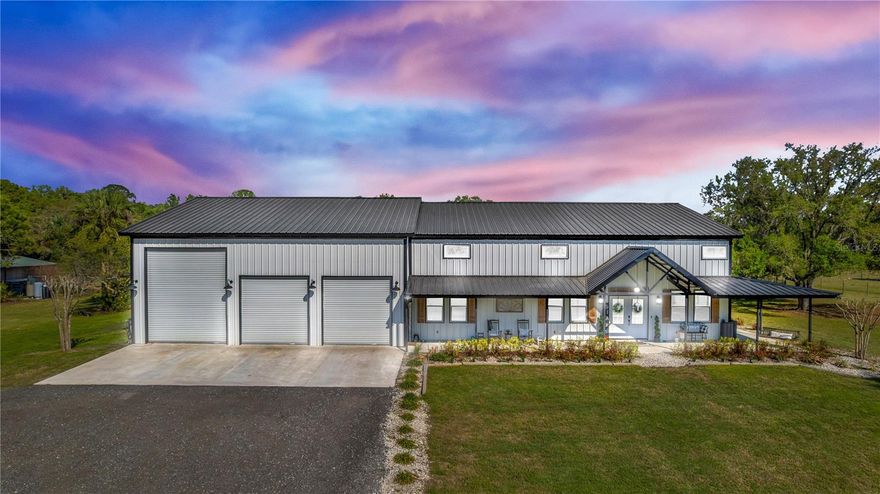 Welcome to your ULTIMATE modern farmhouse dream—where luxury meets wide-open living on 5 PRISTINE ACRES! This newly built barndominium is more than a home; it’s a lifestyle. This one-of-a-kind 3 bedroom, 3 bathroom PLUS an office offers the perfect blend of luxury, functionality, and open country living. With 2,250 square feet of beautifully finished living space complemented by a 2,000 square feet shop with an ADDITIONAL 2,250 square feet UNFINISHED upstairs, this property offers incredible flexibility for future expansion while still delivering high-end custom features throughout. Arrive through the stunning gated entrance and experience the perfect blend of privacy and functionality, with 3 fully fenced acres ideal for livestock and country living at its finest. Step through the double beautiful French glass doors into a thoughtfully designed home that immediately impresses. The kitchen is truly the heart of the home, featuring an impressive 8'x8' island designed for gathering and entertaining. Outfitted with quartz countertops, soft-close cabinetry, and exceptional storage with additional cabinetry on both sides of the island, this space blends beauty with functionality. Enjoy high-end conveniences including a custom hood, built-in drink fridge, microwave drawer, farmhouse sink, pot filler, and a custom-built pantry offering abundant storage. The main living area showcases a warm and inviting atmosphere with a striking electric fireplace set against a beautiful shiplap accent wall featuring floating shelves. Leading to the laundry room, you will find a custom glass barn door, adding both elegance and continuity to the home’s modern farmhouse design. The laundry room features built-in hampers, custom cabinetry, and a farmhouse sink. The office is equally impressive, highlighted by custom glass barn doors, creating a stylish and private workspace. The primary suite serves as a private retreat with a spa-inspired bathroom featuring dual vanities, a floating soaking tub, mirrors with built-in lighting, a spacious 4x6 walk-in shower with bench seating, and a custom-designed closet. Step outside and discover an entertainer’s paradise with over 1,700 square feet of porch space. Enjoy a bar-style setup with seating, a dedicated cook space, plus a sink and refrigerator. Unwind in the oversized hot tub or gather around the firepit under the stars. For those needing space to work or play, the property includes a massive 2,000 sq ft shop with drive-thru capability, a 12x14 garage door, additional 10x10 doors, and dual entry access. A 50-amp RV hookup and a 24x30 detached storage shed add versatility. Rarely does a property combine such craftsmanship with this much room to grow. This is a rare opportunity to own a turnkey estate offering both the peace of the country and the architectural prestige of a designer's masterpiece. Located within a small, private HOA with exclusive access to a private boat ramp on the St. Johns River—perfect for enjoying Florida living at its finest. Discover the perfect balance of grit and grace—schedule your private showing today! Property may be under audio and visual surveillance.