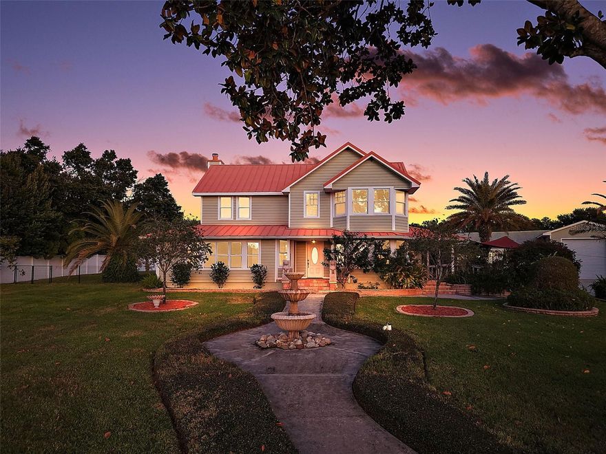 Nestled on 4+ fully fenced & cross-fenced acres, this custom-built retreat offers over 3,460 sq ft of refined living. Five spacious bedrooms and 3.5 baths provide a flexible floor plan tailored for multigenerational living. This is a tranquil estate where every detail has been thoughtfully designed for lifestyle, comfort, and versatility.

As you enter the property, you’re greeted by a charming, covered garden bench and a private drive that winds its way toward the home. A quaint walkway lined with lush landscaping and a bubbling fountain creates a warm, inviting path to the front door. Brick-lined covered porches overlook the private yard and a storybook footbridge that crosses a beautiful koi pond. The outdoor space is ideal for entertaining, featuring a well-appointed kitchenette and BBQ area with commercial-grade venting—perfect for enjoying the very best of outdoor cooking.

Step inside this thoughtfully designed home featuring luxury vinyl flooring and light-filled rooms, including a living room with a wood-burning fireplace. The front sitting area is perfect for watching sunsets or enjoying views of the beautiful grounds.

The well-equipped kitchen boasts Corian countertops, stainless steel appliances, a built-in oven, ceramic cooktop, breakfast bar, walk-in pantry and a pass-through window to porch- great for entertaining. The dining area features bay windows overlooking the front yard.

The cozy family room connects to the primary suite and offers French doors leading to the porch, creating a seamless indoor-outdoor living experience.

The spacious primary suite is a private haven, featuring French doors that open to the porch. The luxurious primary bathroom boasts a clawfoot tub, double vanity, a large glass enclosed no-step walk-in shower, a private water closet, a walk-in closet, and a door leading to a private patio with a fenced dog run. The main floor also provides a half bath, laundry room with lots of cabinets space, utility sink, extra refrigerator, washer and dryer with door leading to side porch. Upstairs, four additional bedrooms and two nicely appointed baths- one of them ensuite- provide ample room for family or guests.

The 1672 sq foot detached garage is a true standout. A portion is sectioned off with commercial grade floor to ceiling storage shelves, 12×10 roll-up doors on both ends for easy drive through access, exterior RV parking pad with a 208 volt / 50 amp power hookup!  Nearly 1000 square feet of the garage is a climate controlled versatile space with full bathroom and kitchenette. It could also be converted back to a traditional garage as the roll up doors on the inside are still in place. There is plumbing in place for outdoor shower, and the side yard offers a mini orchard with fruit trees. (Myer Lemon, Minneola Tangelo, Lime & Avocado). 

Situated on a gentle hill, this property captures gorgeous sunsets over Lake Eldorado and a peaceful ambiance. With 4 fenced acres there is plenty of room for additional buildings, vehicles, animals and gardens.  There is also an additional rear entrance off County Road 44A for convenience.  

Located just minutes from downtown Eustis, Mount Dora, and Tavares, you're close to boutique shopping, lakeside dining, and Florida’s charming small-town culture. And you're less than an hour from Orlando International Airport, Winter Park, airports and major attractions.  County taxes, well and septic save you money!