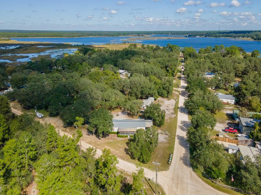 Waterfront Retreat on Canal to Little Lake Kerr – 24797 NE 135 Street, Salt Springs, FL 32134
3 Bedrooms | 2 Bathrooms | 1,440 Sq Ft | .55 Acre | Fenced | Covered Patios | Updated Systems

Welcome to your private canal-front escape! This beautiful .55-acre fenced property offers 250 feet of canal frontage leading to Little Lake Kerr, one of Central Florida’s most scenic and recreation-rich waterways. Located in the heart of the Ocala National Forest, this home combines nature, comfort, and functionality in one tranquil setting.

The 1976 manufactured home features 3 bedrooms, 2 bathrooms, and 1,440 sq ft of living space. The open floor plan includes a spacious living room, dining area, and a large kitchen complete with an island, extensive cabinetry, generous counter space, and all appliances included. The primary suite is oversized with two closets and an en suite bath featuring an oversized vanity and seated shower. Guest bedrooms are cozy in size, and the guest bath includes a tub/shower combo.

Bedroom 3 opens to a 12’x24’ covered wood deck, perfect for relaxing in the shade. The laundry room is thoughtfully designed with a washer and dryer, pantry, and extra storage, and leads to a full-length 8’x60’ concrete patio with a covered roof, ideal for outdoor entertaining or morning coffee with water views.

The property is fenced with a large automatic gate, concrete parking pad, storage shed and container, and features lightning protection, a fruit-bearing orange tree, and majestic oak trees that welcome daily visits from local wildlife, including white-tailed deer.

Recent updates include:

Roof (approx. 9 years old)

HVAC system (approx. 10 years old)

Septic drainfield and pumping (2023)

The Kerr Shores Subdivision offers voluntary membership to the community park, which includes a clubhouse (currently being renovated), boat ramp, dock, playground, picnic tables by the water’s edge, and beautiful white sand beaches—the perfect setting for lakefront gatherings.

Perfectly positioned for outdoor adventure, you’re minutes from Salt Springs Recreation Area, Lake George, and the St. Johns River, offering world-class fishing, boating, hiking, and hunting. The nearby Ocala National Forest features miles of ATV, horseback, and walking trails. Just 10 minutes to Fort McCoy for groceries and dining, and a short drive to Silver Springs, Ocala, or Palatka for shopping and entertainment.

Whether you’re looking for a full-time residence, seasonal retreat, or nature lover’s getaway, this property delivers the best of Florida’s outdoor living.
