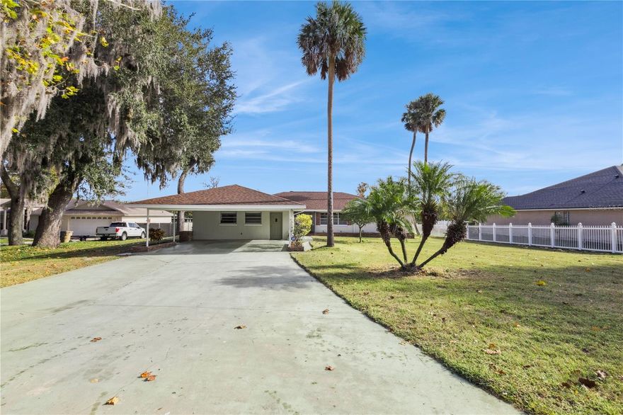 Imagine your mornings, coffee in hand on your screened-in porch, surrounded by the quiet rhythm of nature. With a preserve just across the canal, the sound of birds singing, sparkling water views, you have a level of privacy that feels like a true retreat. Located in highly sought-after Venetian Village, this property blends community charm with peaceful waterfront living. A fenced yard, boathouse, and shed offer plenty of space for hobbies and storage, while your private dock with boat lift invites fishing, sunset cruising, and effortless days on the water. By boat, you're minutes from the open waters of the Harris Chain of Lakes and a scenic ride away to historic Mount Dora, where you can dock for live music, charming shops, and a culinary array of cuisines to experience.  Back at home, weekends flow easily. Host friends for dinner and drinks inside or outside, watch little ones play in the yard, or simply unwind with the peaceful panoramic views. Inside, the open layout brings natural light and water views into nearly every room. The kitchen’s generous counter space and storage will inspire your inner chef, while the spacious living room—with oversized French windows—allows that retreat experience to overflow inside. The enclosed sitting room off the primary suite offers another quiet space to relax, complete with its own access to the backyard. Don’t just live near the water—live a life shaped by it.